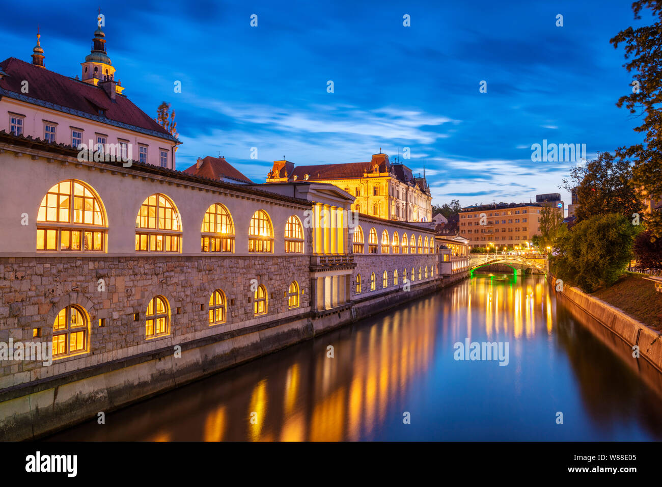 Le riflessioni degli archi della centrale di mercato coperto posto colonne di Plečnik Portici nel fiume Ljubljanica di notte Ljubljana Slovenia EU Europe Foto Stock