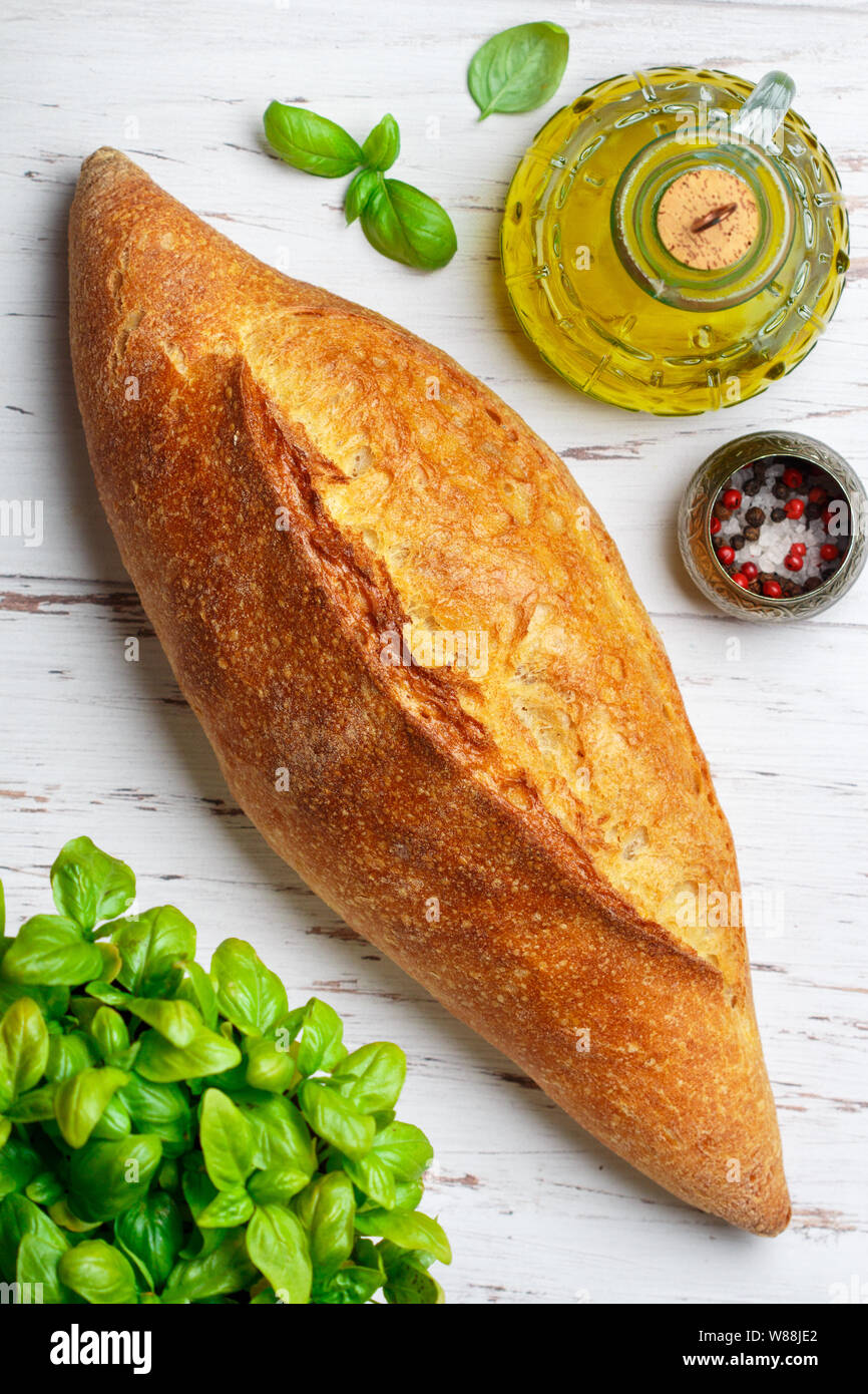 Pane appena sfornato in casa pane di grano. Una forma di pane intera sul tavolo. Stile rustico. Messa a fuoco selettiva Foto Stock