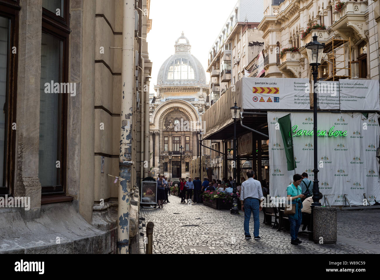 Una strada acciottolata nella città vecchia di Bucarest con un ristorante Caru' cu bere superiore locale sulla destra. Foto Stock