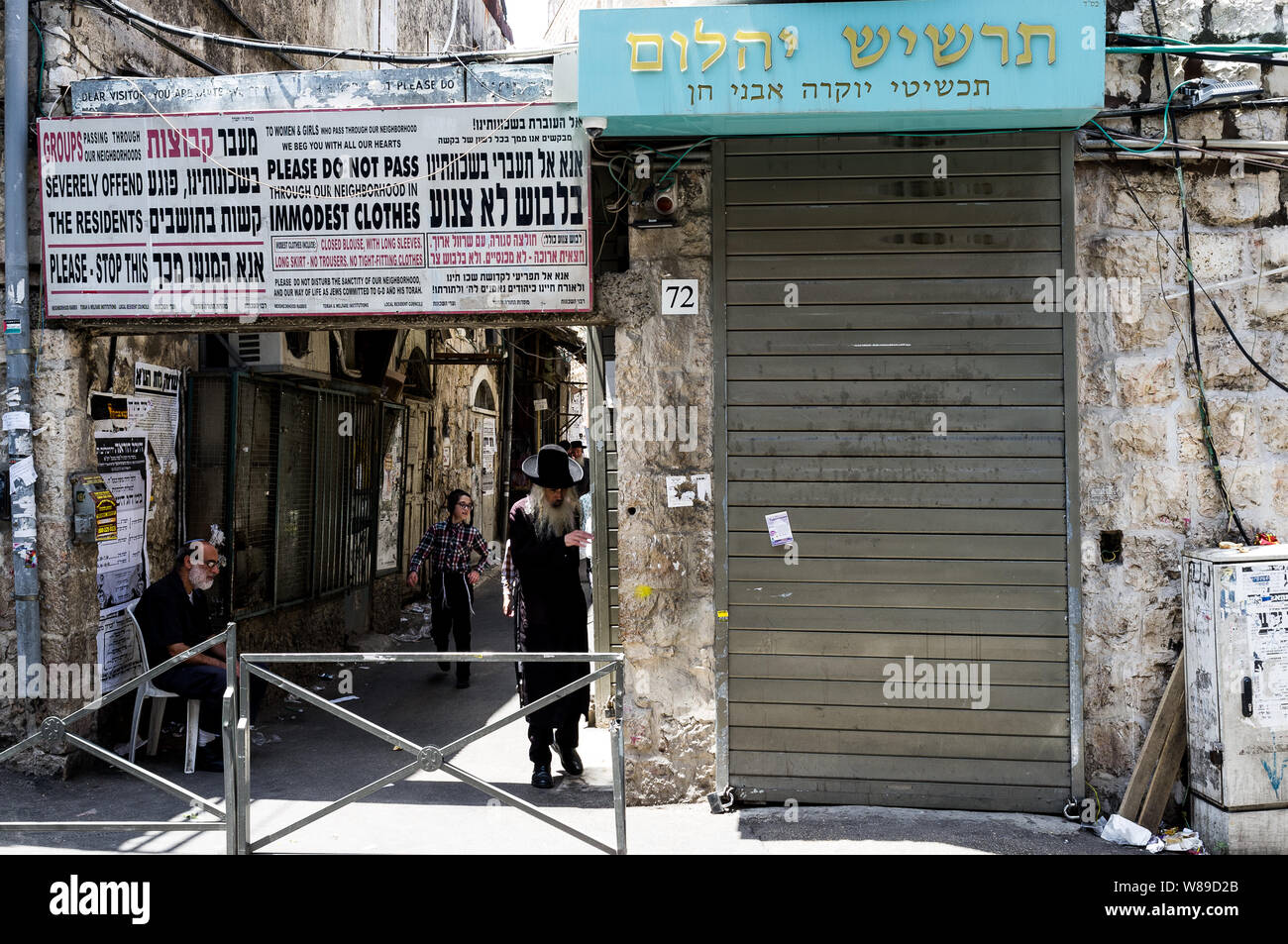 Una strada alla periferia di Mea-Shearim, il quartiere ebraico ultra-ortodosso di Gerusalemme con un cartello modesty con le istruzioni per i visitatori Foto Stock