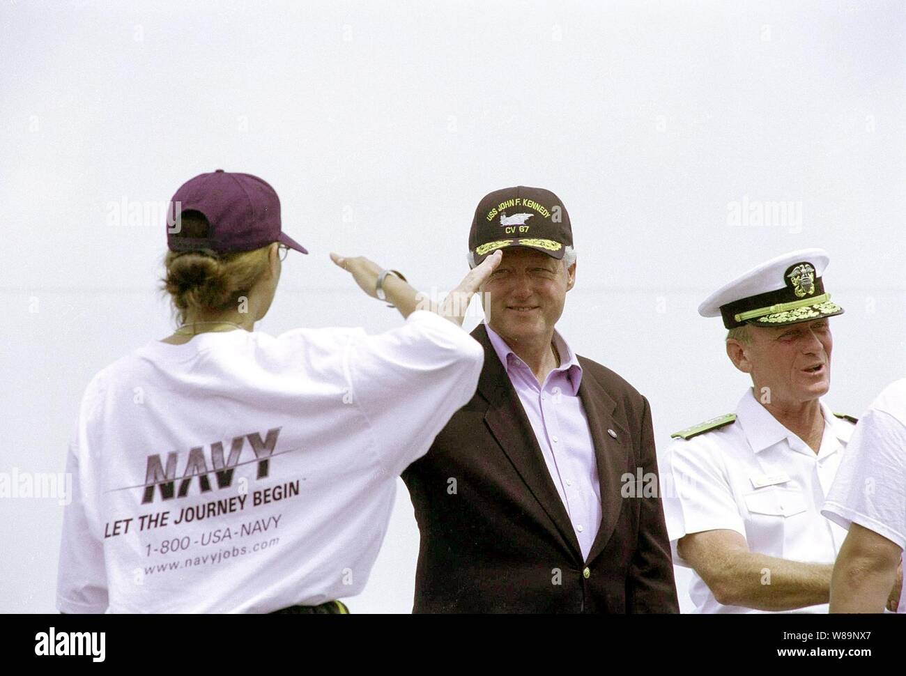 Il presidente Bill Clinton saluta felicemente un nuovo marinaio arruolato in seguito ad una speciale cerimonia di arruolamento a bordo della USS John F. Kennedy (CV 67) nel porto di New York, il 4 luglio 2000. Clinton ha amministrato il giuramento di arruolamento per un gruppo di reclute della marina sulla carrierХs ponte di volo. Il presidente era sulla portaerei a ricevere riconoscimenti da parte delle navi come hanno passato in rassegna durante il navale internazionale di revisione e funzionamento Sail 2000. Foto Stock