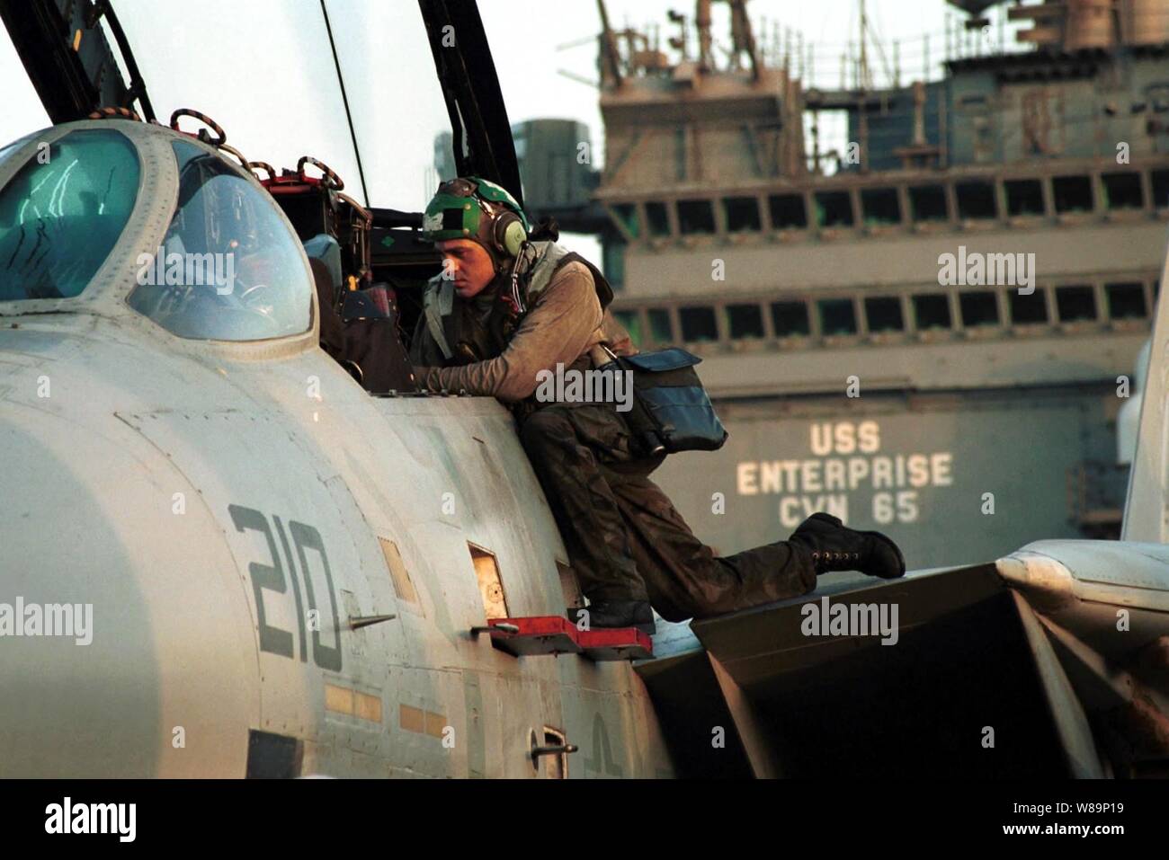 Un membro dell'equipaggio prepara un F-14A Tomcat per le prossime operazioni di volo a sostegno dell'Operazione Enduring Freedom sul ponte di volo della USS Enterprise (CVN 65) il 7 ottobre 2001. Gli aeromobili sono predisposte per colpire le missioni contro al Qaeda terroristici dei campi di addestramento e installazioni militari del regime dei talebani in Afghanistan. La attentamente le azioni mirate sono state progettate per interrompere l'uso dell'Afghanistan come una base per azioni terroristiche e di attaccare le capacità militari del regime dei talebani. Foto Stock