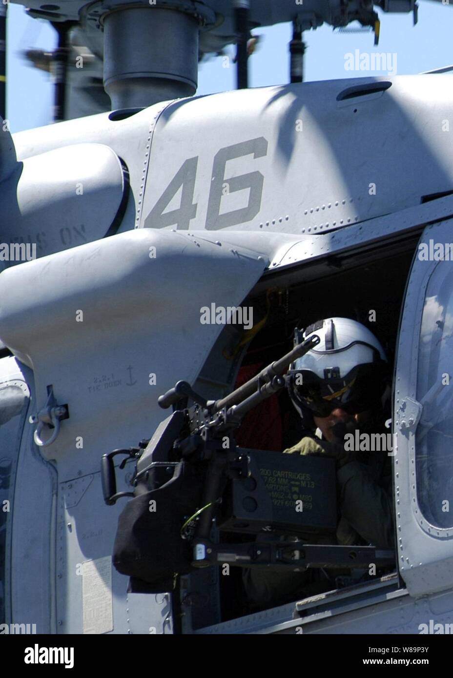 Navy Petty Officer di terza classe Nick Tookenay mans pistola montata su un MH-60S Knighthawk elicottero come si decolla da ponte dell'assalto anfibio nave USS Kearsarge (LHD 3) il 20 giugno 2004. La Kearsarge è il trasporto di elementi del ventiquattresimo Marine Expeditionary Unit a sostegno dell'Operazione Iraqi Freedom. Foto Stock