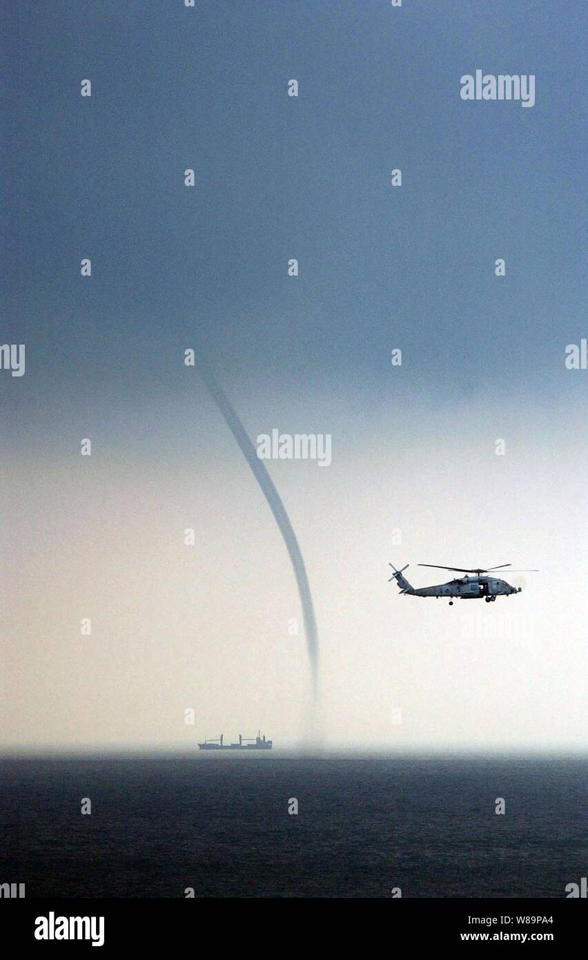 Una Marina HH-60H Seahawk elicottero mantiene una diffida occhio su una nave nelle vicinanze e un trombe mentre il pattugliamento nel Mar Cinese meridionale al largo della costa della Malesia sul Sett. 5, 2004. Il Seahawk è attaccato ad un elicottero Anti-Submarine Squadron 4 dalla stazione navale Isola del nord a San Diego, California Foto Stock