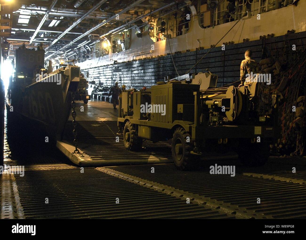 Stati Uniti Navy Seabees caricare i macchinari e le attrezzature su una Landing Craft Utility in ben coperta dell'assalto anfibio nave USS Saipan LHA (2) per il trasporto a terra su Haiti nel Febbraio 3, 2005. La Saipan è distribuito come supporto di nuovi orizzonti, l'assistenza umanitaria fornita in Haiti. Durante nuovi orizzonti le forze USA costruirà schoolhouses, la perforazione dei pozzi e fornire cure mediche alla popolazione di Haiti. Foto Stock