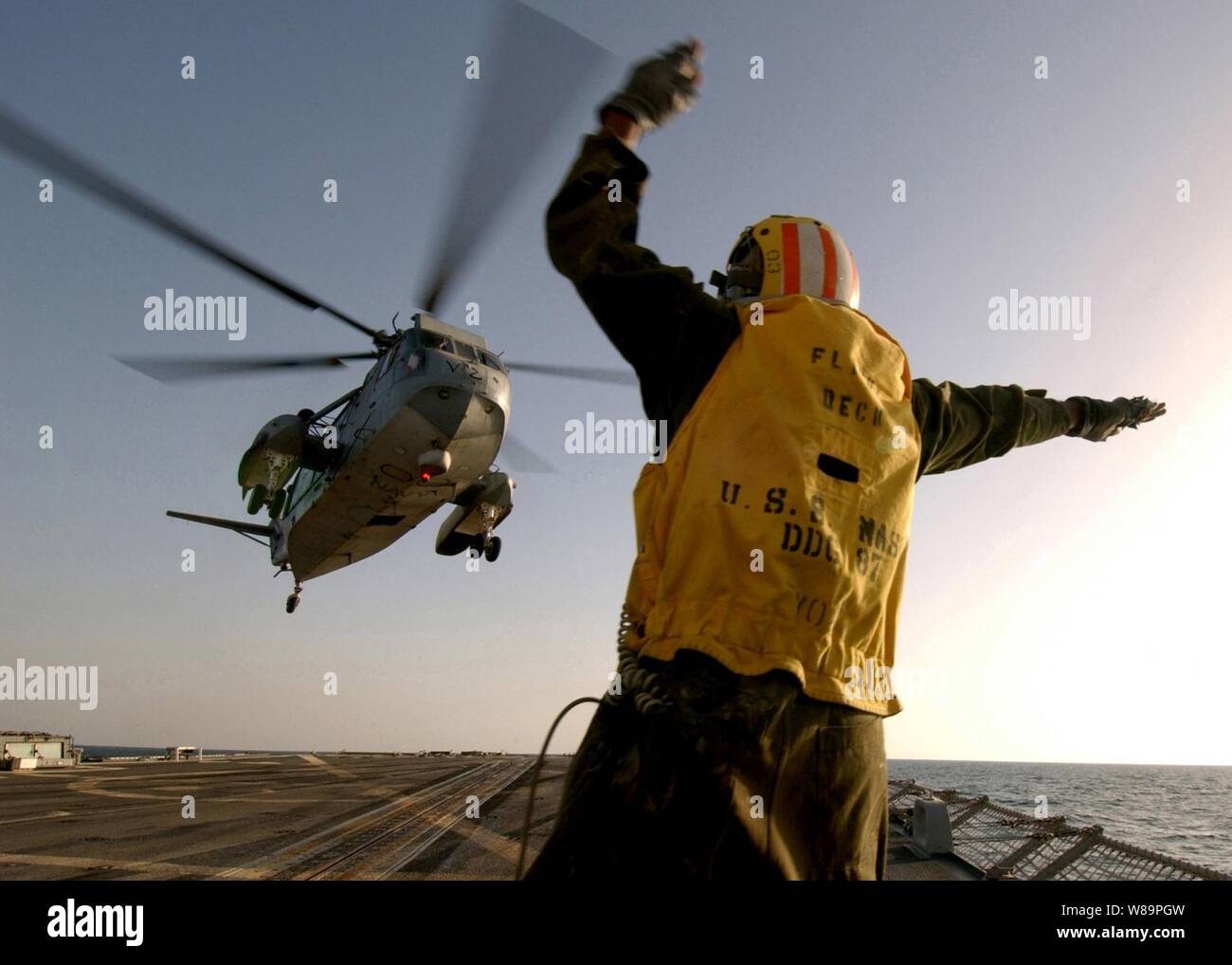 Petty Officer 2a classe Itro Duncan segnali pilota di un H-3 Sea King elicottero che è libero di muoversi in allontanamento dal ponte di volo della USS Mason (DDG 87) come la nave opera nel Golfo Persico il 5 febbraio, 2005. Il Arleigh Burke Cacciatorpediniere classe sta conducendo le operazioni nel Golfo come parte del destroyer Squadron 26 e la USS Harry Truman (CVN 75) il vettore Strike gruppo. Il re del mare, da un elicottero di combattimento squadrone di supporto 2 e la USS Mason sono entrambi schierati da Norfolk, Virginia Foto Stock