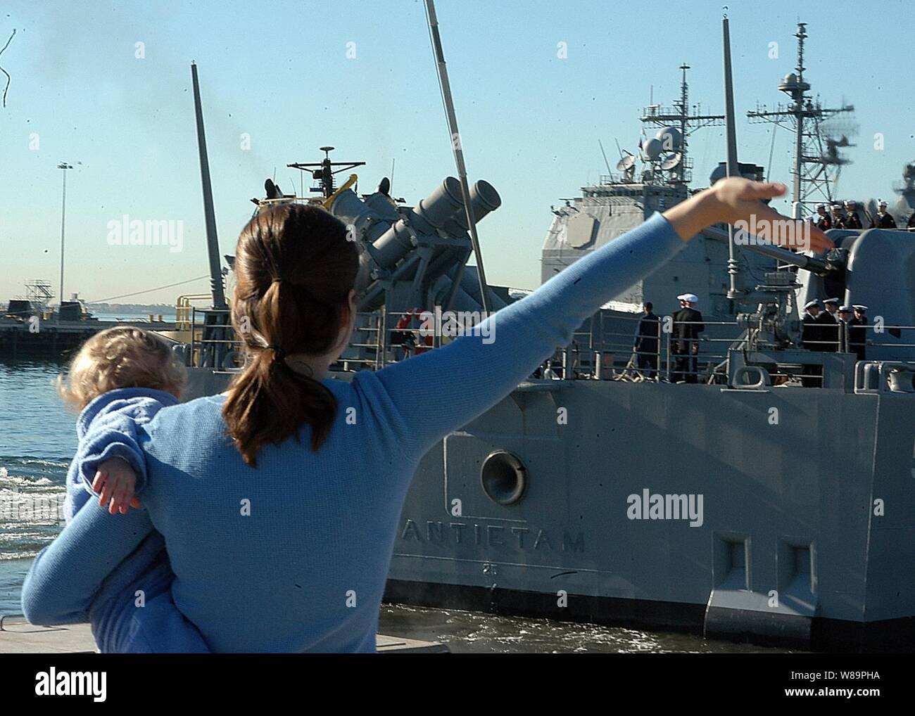Un curioso onde addio come guidato-missili cruiser USS Antietam (CG 54) si diparte dalla stazione navale Isola del nord, San Diego, California, il 1 febbraio 2005. Antietam è inizio sei mesi di distribuzione come parte dell'USS Carl Vinson (CVN 70) il vettore Strike gruppo. Foto Stock