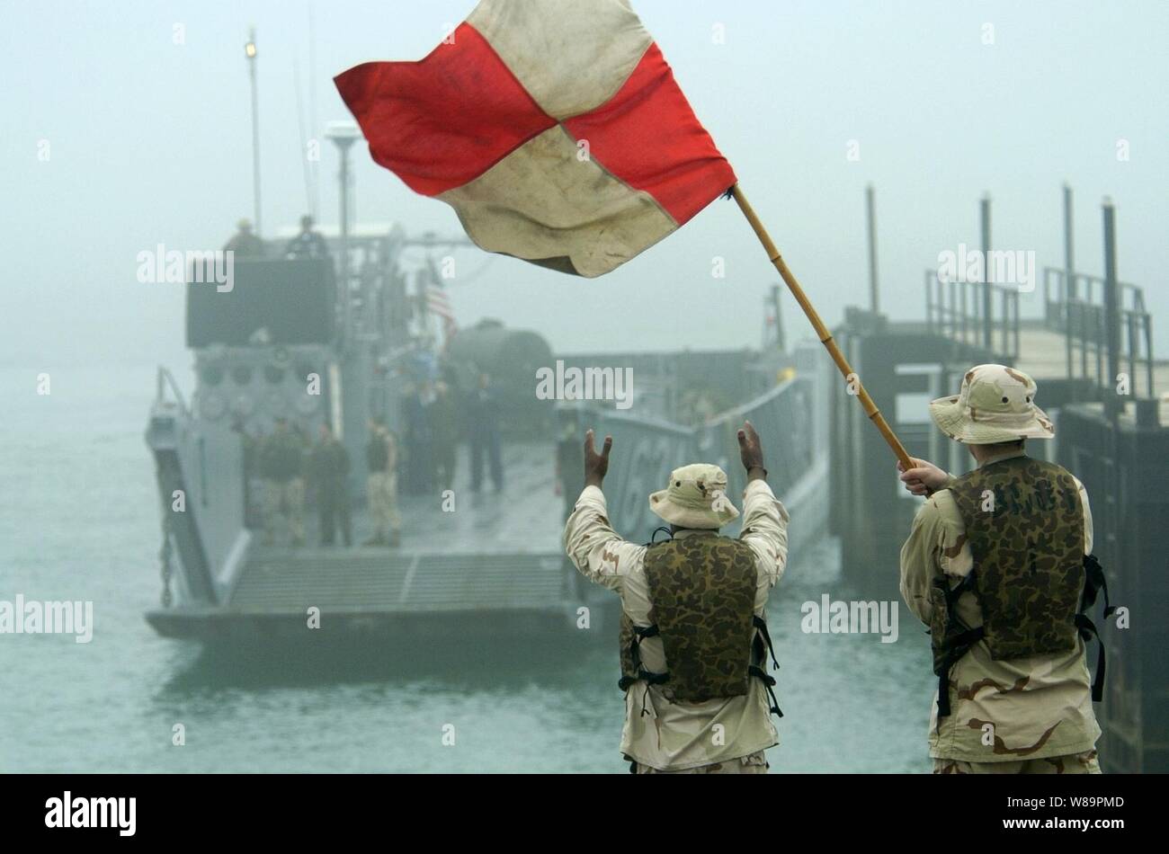 Marinai Jinhan Chen (sinistra) e Michael Kincade direct Landing Craft Utility 1634 ad una rampa di barca a Kuwait Base Navale nel Febbraio 26, 2005. Il Landing Craft sarà a carico di Marines assegnato al trentunesimo Marine Expeditionary Unit e il loro trasporto al dock di anfibio sbarco nave USS harpers Ferry (LSD 49). I marines della trentunesima è stato distribuito in Iraq dal luglio 2004. Chen e Kincade sono assegnati a assalto unità artigianali 1del Naval Amphibious Base, Coronado, California Foto Stock