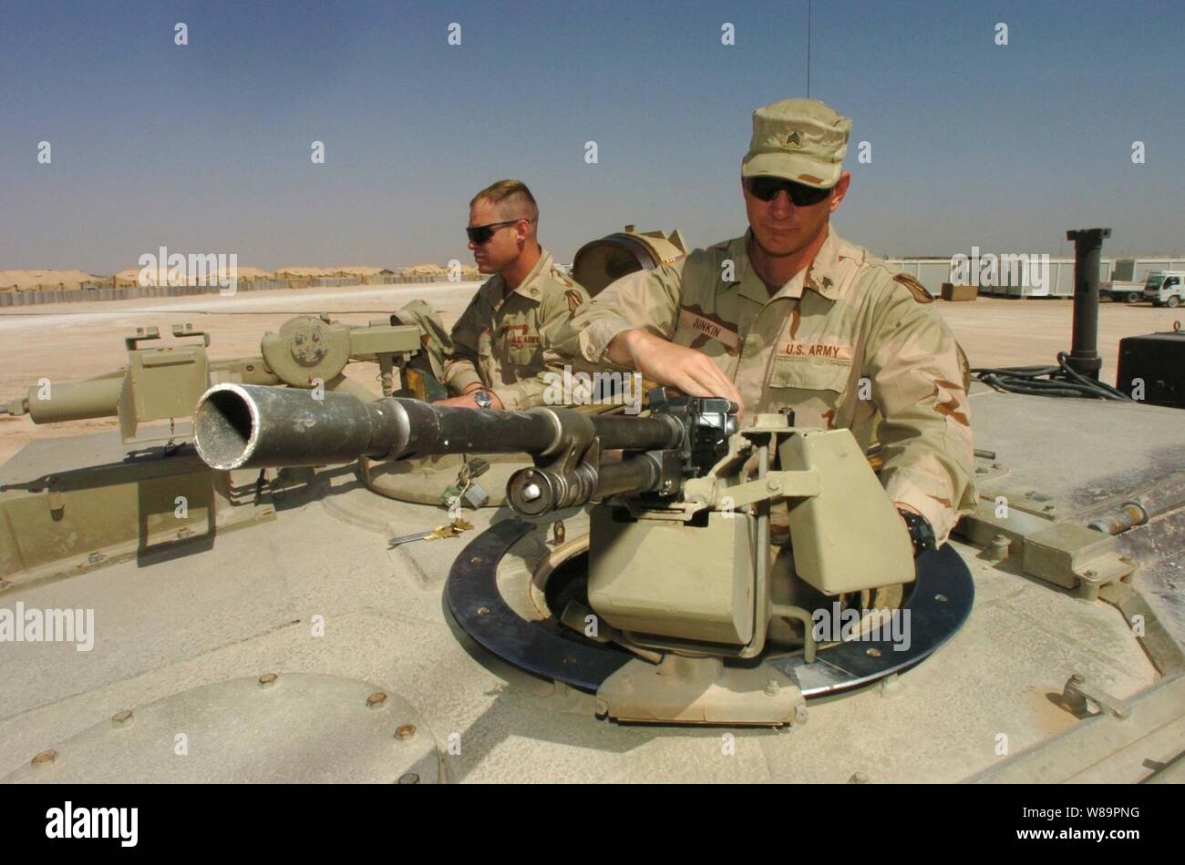 Stati Uniti Army Sgt. Scott Junkin (destra) monta un M-240 Pistola macchina sulla parte superiore di un M1A1 Abrams serbatoio come lui e lo Staff Sgt. Contrassegnare Gillentine fare i preparativi per una prossima missione a inoltrare una base operativa Hotel in provincia di Najaf, Iraq, il 30 marzo 2005. E Junkin Gillentine sono con Bravo Company, 1° Battaglione, 198th Armor, 155vigili del Team di combattimento, distribuito da Tupelo, Miss., a sostegno dell'Operazione Iraqi Freedom. Foto Stock