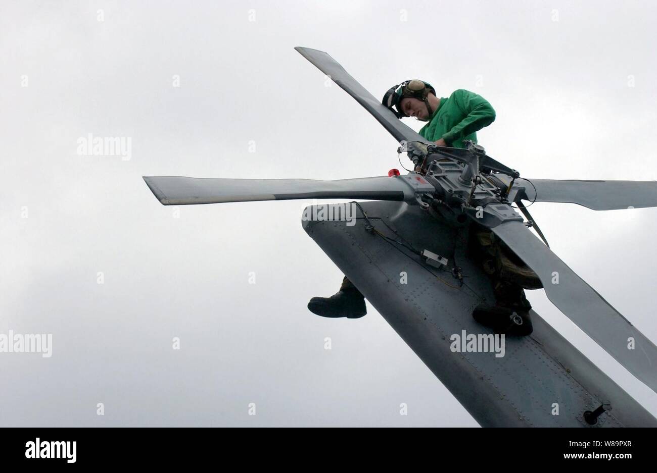 Petty Officer di terza classe Adam Barbiere posatoi sulla coda di una SH-60F Seahawk come egli sostituisce l'elicottero di anti-urto leggero a bordo della portaerei USS Nimitz CVN (68) il 10 giugno 2005. Il barbiere è un Navy Aviation da elettricista, Mate assegnato all'elicottero Anti-Submarine Squadron 6 distribuito a bordo della Nimitz dalla Naval Air Station North Island, San Diego, California Foto Stock