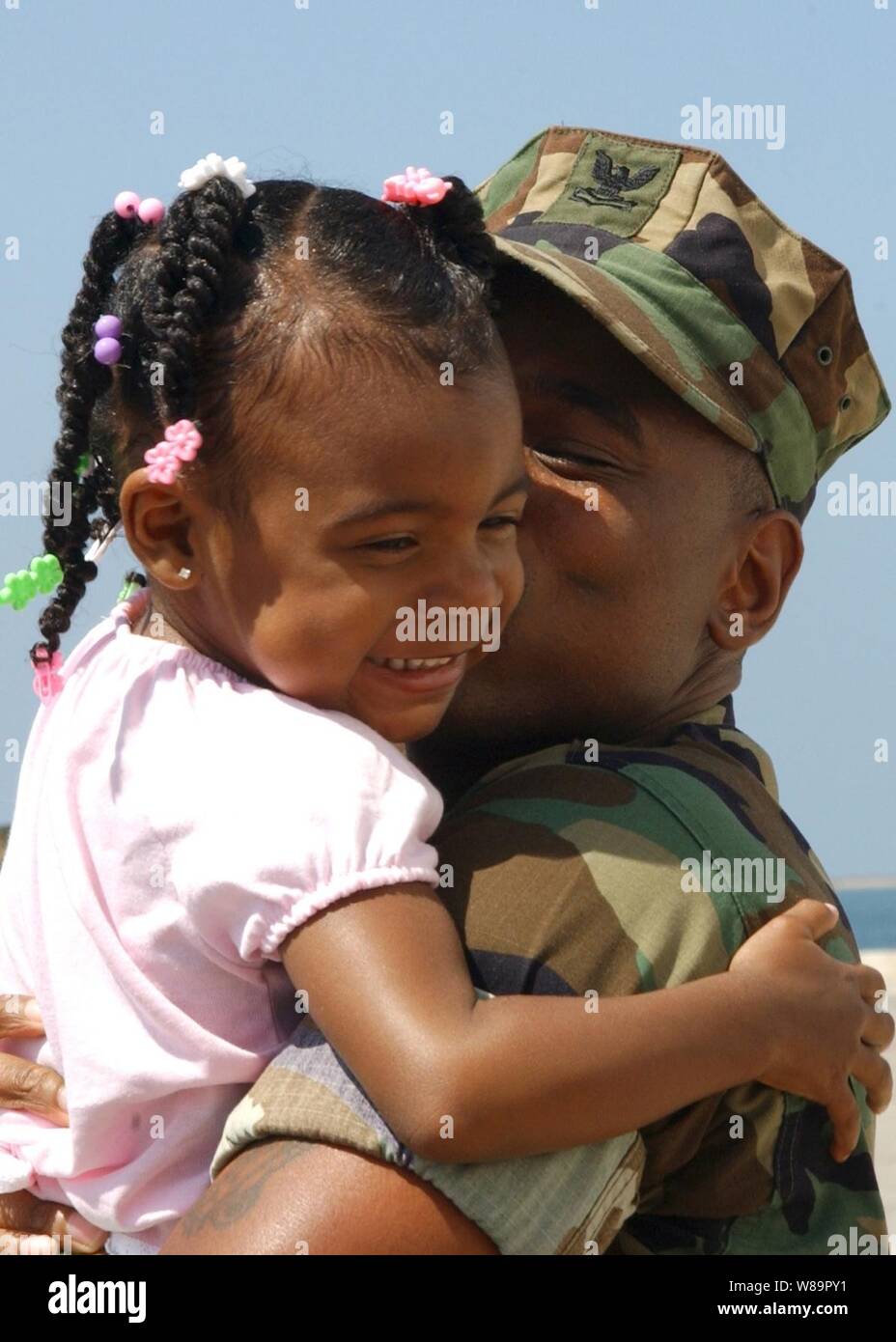 Eriona Underwood avvolge il suo padre Petty Officer 2a classe Erik Underwood dopo la nave ospedale USNS misericordia restituito alla stazione navale di San Diego, California, il 8 giugno 2005. La USNS misericordia (T-AH 19) restituito dopo la fornitura di aiuto in caso di catastrofe nel sud-est asiatico dopo il 26 dicembre 2004, lo tsunami. Durante la distribuzione di più di 100.000 pazienti sono stati trattati e oltre 400 interventi chirurgici sono state eseguite. Foto Stock