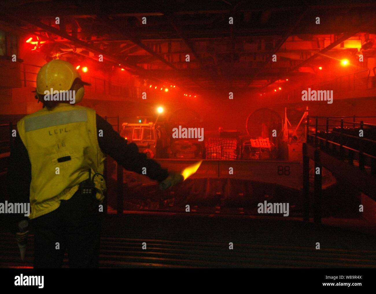 Stati Uniti Navy Seaman Tysha Cooper segnali a landing craft cuscino d'aria che si prepara a discostarsi ben coperta della USS Iwo Jima (LHD 7) su 1 Ottobre, 2005. L'Iwo Jima è ritornare a Norfolk, Virginia, a seguito di rilievo e i tentativi di recupero come parte della Joint Task Force Katrina. Dipartimento della Difesa le unità sono mobilitati come parte della Joint Task Force Katrina per supportare la Federal Emergency Management Agency di disaster relief sforzi in Costa del Golfo luoghi devastati dall' uragano Katrina. Foto Stock Stati Uniti Navy Seaman Tysha Cooper segnali a landing craft cuscino d'aria che si prepara a discostarsi ben coperta della USS Iwo Jima (LHD 7) su 1 Ottobre, 2005. L'Iwo Jima è ritornare a Norfolk, Virginia, a seguito di rilievo e i tentativi di recupero come parte della Joint Task Force Katrina. Dipartimento della Difesa le unità sono mobilitati come parte della Joint Task Force Katrina per supportare la Federal Emergency Management Agency di disaster relief sforzi in Costa del Golfo luoghi devastati dall' uragano Katrina. Foto Stock