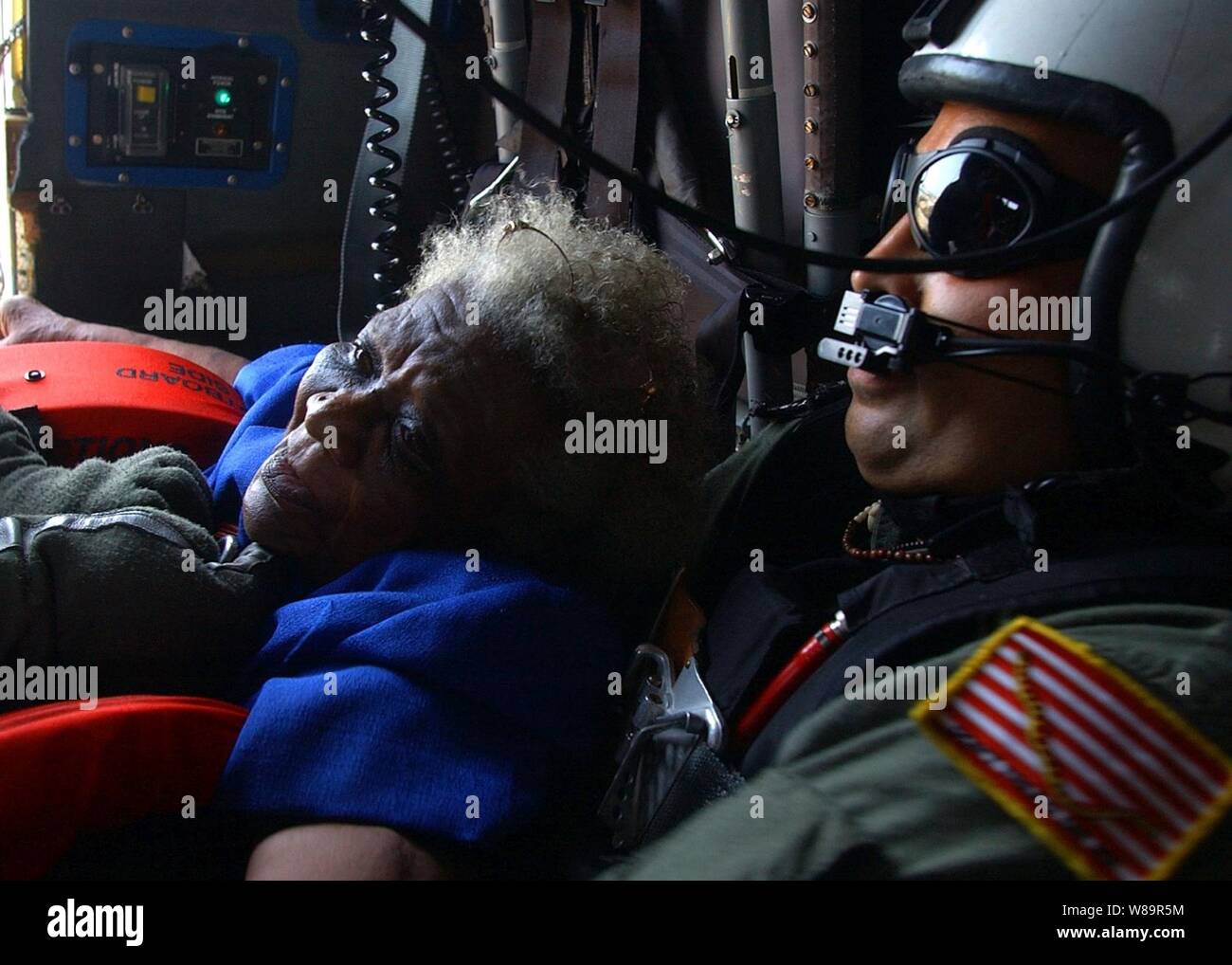 Navy la ricerca e il salvataggio del nuotatore Petty Officer 1. Classe Scott Chun si blocca su un evacuee tirato da un tetto in New Orleans, in Louisiana, come suo SH-60B Seahawk elicottero teste per la zona di atterraggio sul Sett. 5, 2005. Dipartimento della Difesa le unità sono mobilitati come parte della Joint Task Force Katrina per supportare la Federal Emergency Management Agency di disaster relief sforzi in Costa del Golfo luoghi devastati dall' uragano Katrina. Foto Stock