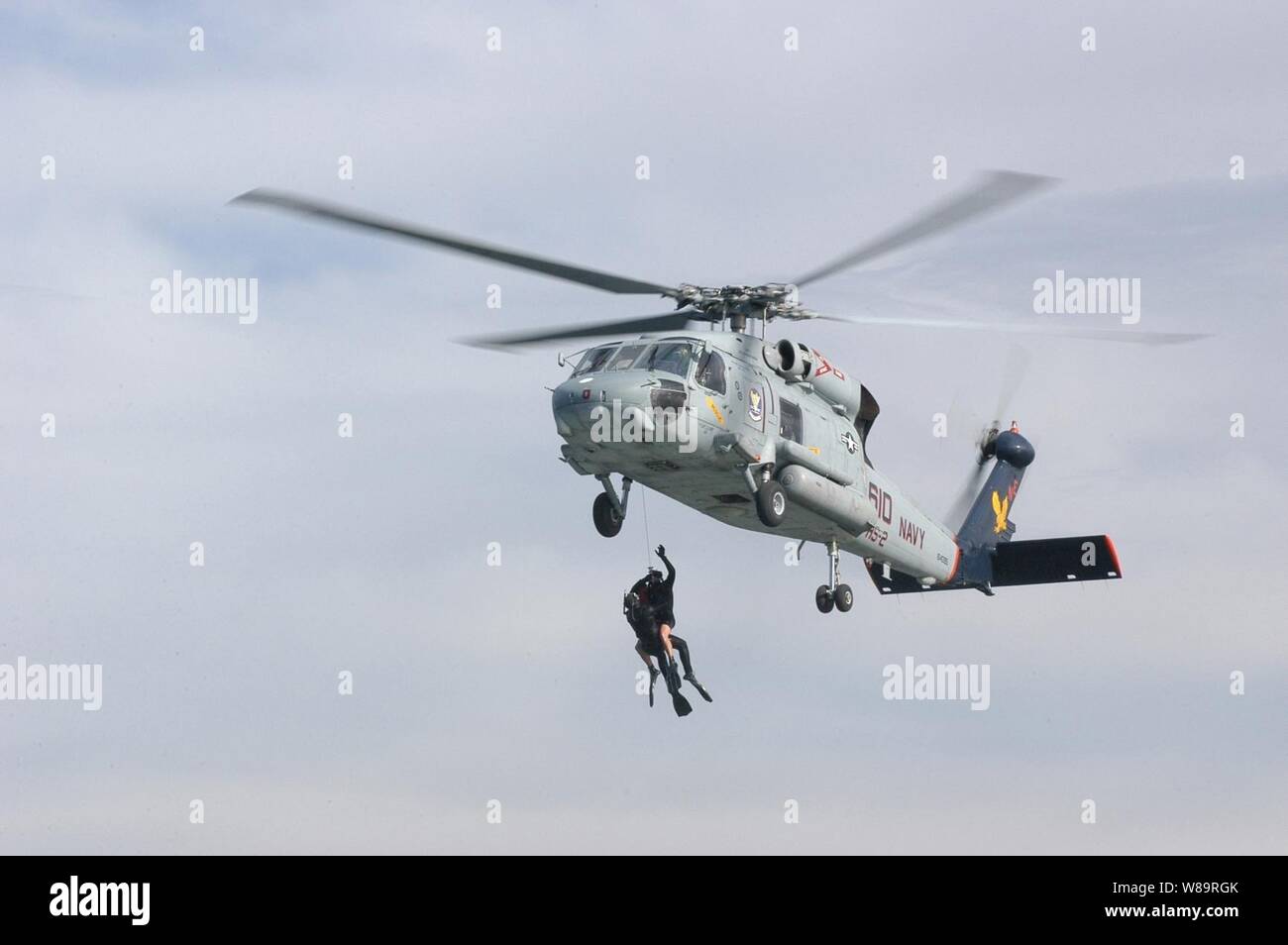 Una Marina SH-60F Seahawk elicottero montacarichi a due operazioni di ricerca e salvataggio nuotatori dalla Baia di San Diego durante la formazione di soccorso a San Diego, California, il 8 febbraio 2006. Il corso di formazione in tempo reale migliora la prontezza operativa e l'efficacia dello squadrone di piloti, equipaggi iscritti e nuotatori di salvataggio. Il Seahawk e il suo equipaggio sono assegnati all'elicottero Anti-Submarine Squadron 2 della Naval Air Station North Island in San Diego. Foto Stock