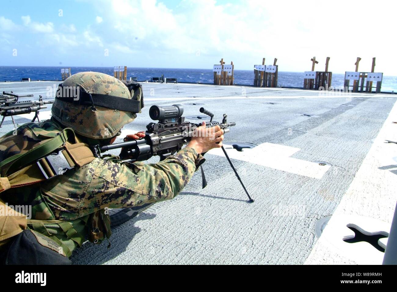 Un U.S. Marine con il trentunesimo Marine Expeditionary Unit regola la sua arma durante una squadra di armi automatiche live-fire esercizio sul ponte di volo del dock anfibio sbarco nave USS harpers Ferry (LSD 49) Nel febbraio 15, 2006. Harpers Ferry, USS Essex (LHD 2) e USS Juneau (LPD 10) sono operanti nel Mare delle Filippine. Foto Stock