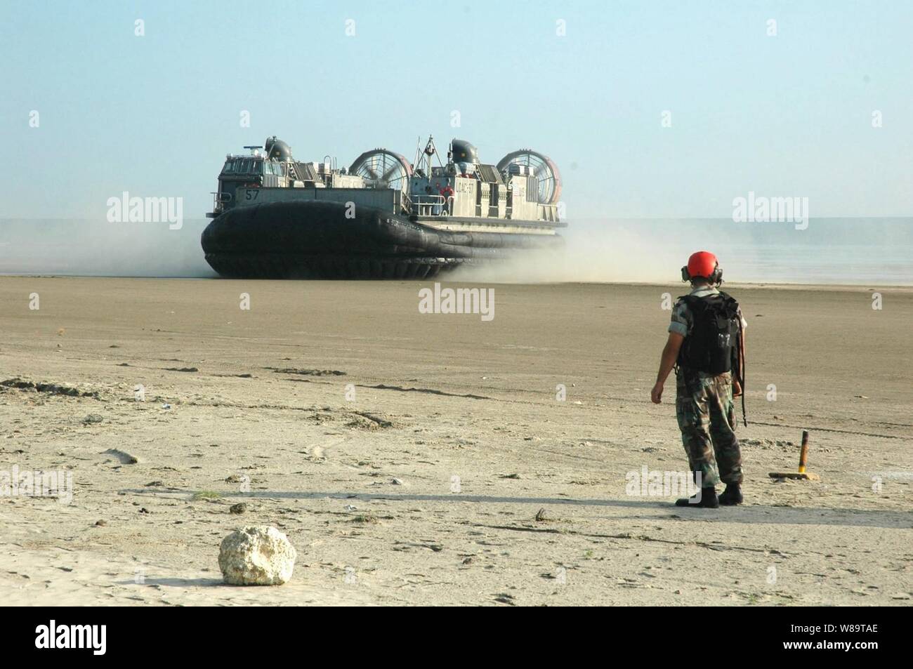 Un U.S. Navy sailor mantiene la spiaggia chiara come un Navy Landing Craft Air Cushion, più comunemente noto come un LCAC, dall assalto unità artigianali 5 giunge a riva di Mersing, Malaysia, il 30 luglio 2006. Il LCAC e il suo equipaggio stanno prendendo parte alla quarta fase di cooperazione a galla la prontezza e la formazione, una serie annuale di marittimi bilaterali esercizi di formazione tra gli Stati Uniti e sei del sud-est asiatico. Foto Stock
