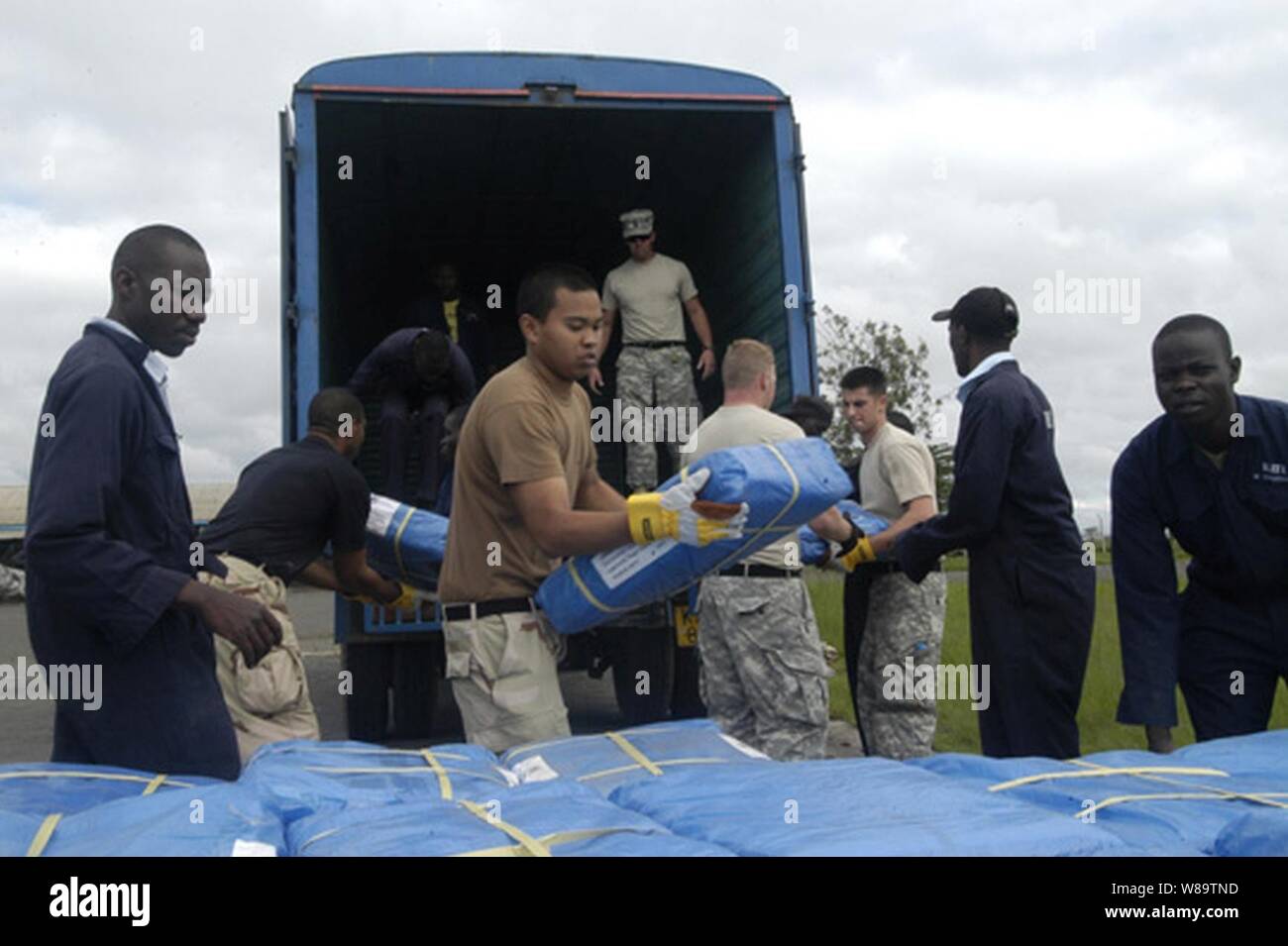 Stati Uniti Navy marinai e soldati aiutare lavoratori keniota che si scaricano rifugi di plastica per le vittime delle gravi inondazioni che hanno colpito la Dadaab, Kenya, a Dic. 10, 2006. Personale di volo NEGLI STATI UNITI, assegnato a Combined Joint Task Force - Corno d Africa, sono aria-la caduta di forniture di soccorso e di aiuto umanitario per i circa 160.000 stranded vittime delle recenti inondazioni nelle zone rurali del kenia. Foto Stock