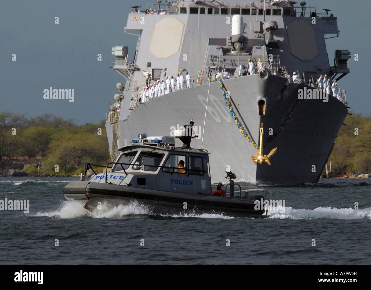 Un porto imbarcazione di pattuglia conduce il modo per effettuare la visita-missile destroyer USS Paul Hamilton (DDG 60) come la nave ritorna alla sua homeport della stazione navale Pearl Harbor, Hawaii, sul 20 agosto, 2007. La Hamilton e la USS O'Kane (DDG 77) tornò a Pearl dopo sette mesi di distribuzione. Foto Stock