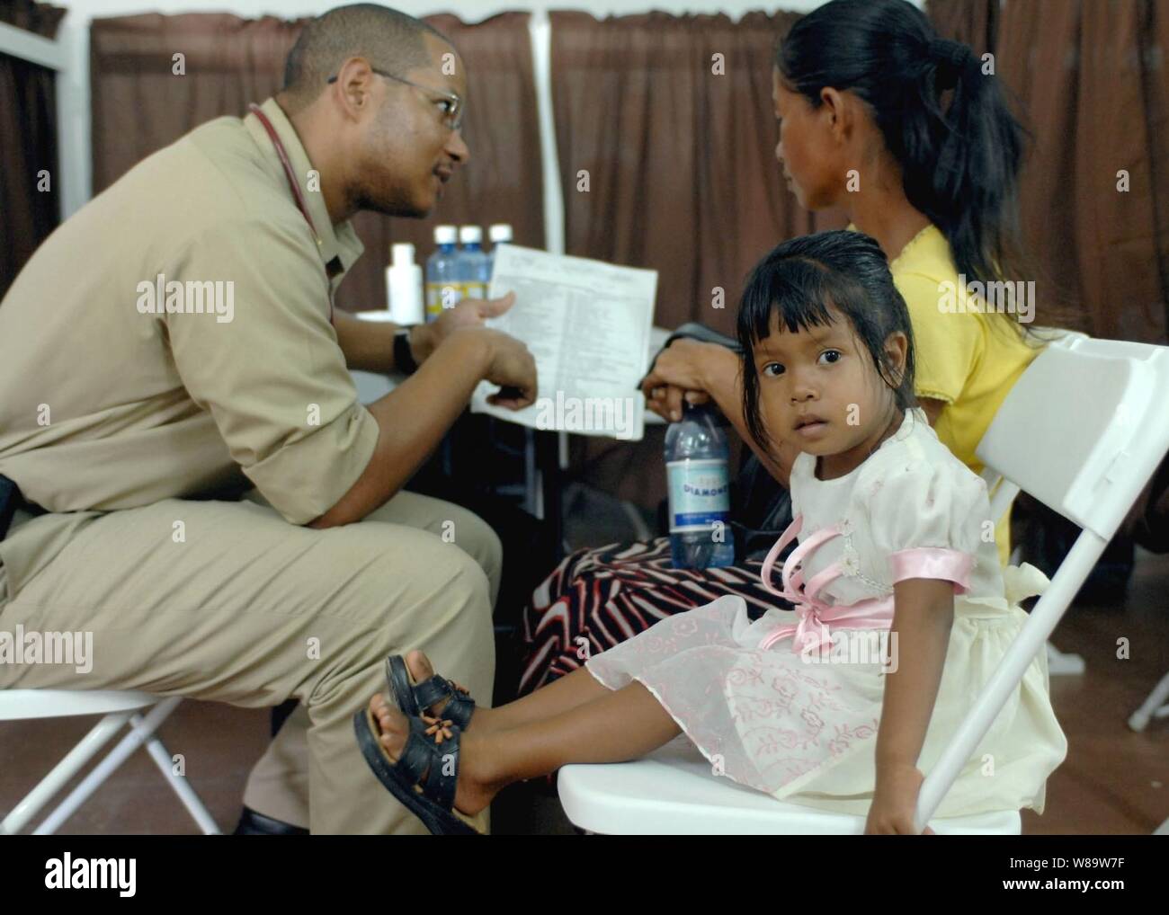 Stati Uniti Servizio Sanitario Pubblico Lt. La Cmdr. Jamal Gwathney parla con Winifred Daniels, madre di tre-anno-vecchio Trisha, all ospedale di Carità in Essequibo, Guyana, sul Sett. 25, 2007. Gwathney è una medicina di famiglia medico attaccata alla nave ospedale USNS Comfort (T-AH 20). Il comfort è su quattro mesi di distribuzione umanitario per l America Latina e i Caraibi fornendo cure mediche ai pazienti in una dozzina di paesi. Foto Stock