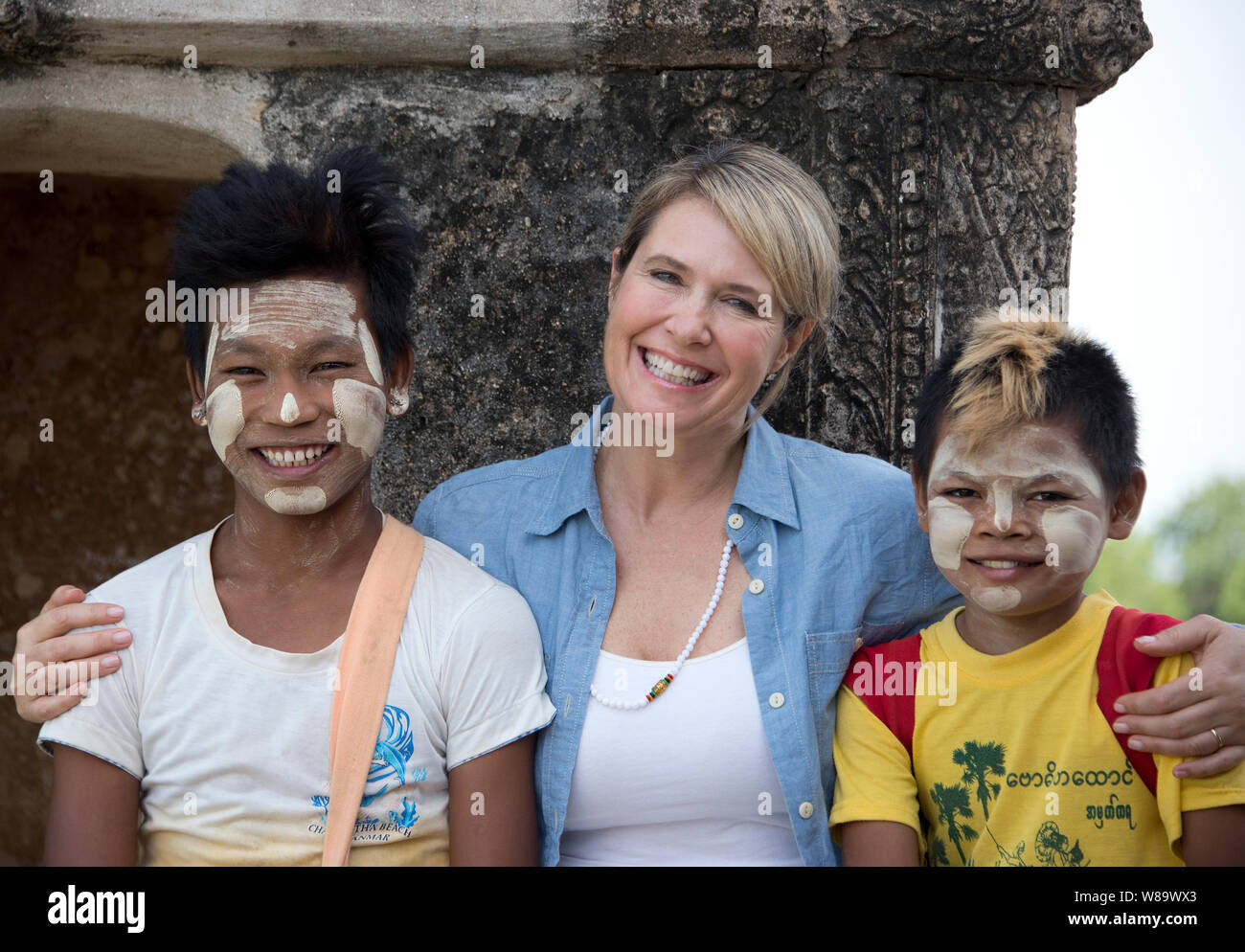 Un Felice turista femminile e due ragazzi birmani che indossano il tradizionale Thanaka Makeupis un bianco pasta cosmetica proteggere la pelle e il turista è rilasciato. Foto Stock