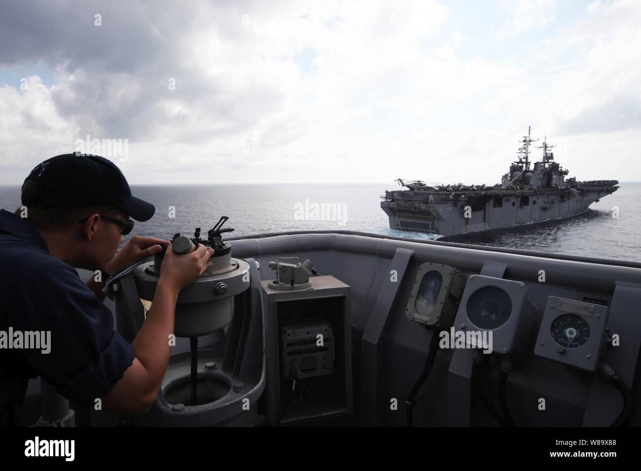 Stati Uniti Navy Ensign Peter Larson utilizza un azimut per trovare la voce all'assalto anfibio nave USS Essex (LHD 2) dall'imbarcadero nave USS harpers Ferry (LSD 49) prima di un esercizio di rifornimento con Essex nel Golfo della Tailandia nel febbraio 24, 2009. Il harpers Ferry e Essex sono distribuite in avanti a Sasebo, Giappone. Foto Stock
