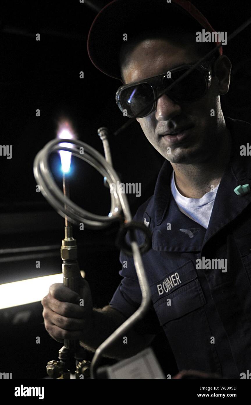 Stati Uniti Navy Petty Officer di terza classe Alex C. Bonner brasature un tubo dotato di manometro da uno delle caldaie a bordo della USS Blue Ridge (LCC 19) mentre è in corso nell'Oceano Pacifico il 17 marzo 2009. La Blue Ridge serve sotto il comandante, Expeditionary Strike gruppo 7 e il comando Task Force 76, la marina è solo avanti-dispiegata la Forza anfibia. La Blue Ridge è l'ammiraglia per il comandante, U.S. 7a flotta. Foto Stock