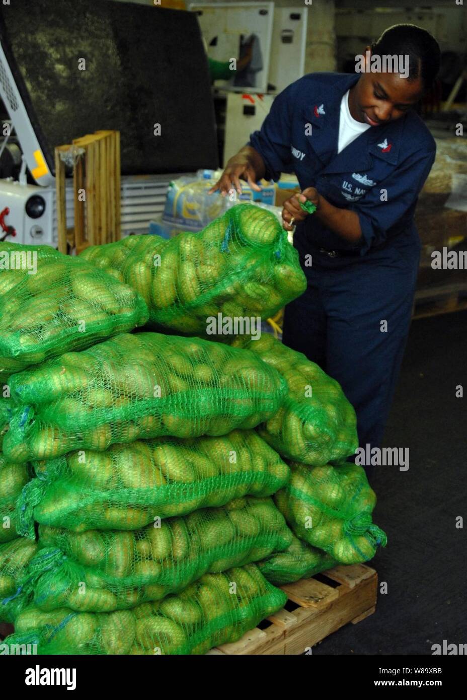 Stati Uniti Navy Yeoman 2a classe Tynesia Gundy pile sacchi di patate ricevuti durante un rifornimento in mare il funzionamento a bordo della portaerei USS Dwight D. Eisenhower CVN (69) nel Mar Arabico il 9 aprile 2009. La Eisenhower Carrier Strike gruppo è in corso di realizzazione per una distribuzione a sostegno della rotazione di avanzamento-forze dispiegate. Foto Stock