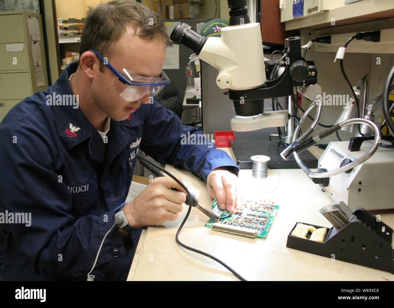 Stati Uniti Navy Electronics Tecnico 1a classe Phillip Makuch conduce una sostituzione di componente su un gruppo idraulico di potenza della scheda di circuito 7 aprile 2009, in Ingleside, Texas. La mia classe di contromisure Squadron e South Central Regionale Centro di manutenzione hanno collaborato per investigare un valido mezzo di riparazione dei sistemi che i marinai non sono stati in grado di fare in passato, risparmiando la Marina 1,1 milioni di dollari nei prossimi anni. (U.S. Navy Foto Stock