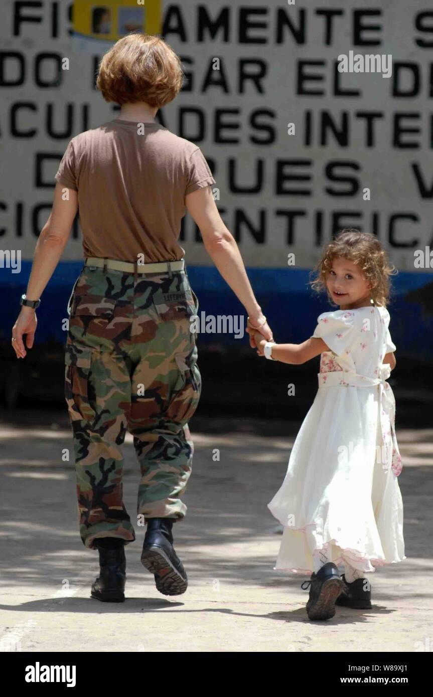 Stati Uniti Navy Cmdr. Alison LeFebvre, un terapista fisico assegnato ai militari di comando Sealift nave ospedale USNS Comfort (T-AH 20), accompagnatrici un salvadoregno El bambino per la terapia fisica durante una missione medica al Jose Pantoja Hija schoolhouse in La Union, El Salvador, il 22 giugno 2009. Il comfort è sulla sua sesta fermata a sostegno della promessa continua 2009, a quattro mesi di aiuti umanitari e di assistenza civica missione in tutta l America Latina e i Caraibi. Foto Stock