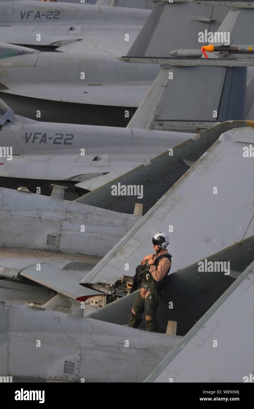Stati Uniti Navy Lt. La Cmdr. James Shell si appoggia sull'ala di un EA-6B Prowler aeromobile assegnati al Tactical Electronic Warfare Squadron 139 prima di operazioni di volo a bordo della portaerei USS Ronald Reagan (CVN 76) nel Golfo di Oman il 18 luglio 2009. Prima delle operazioni di volo squadrone, meccanici e piloti ispezionare i loro aerei per assicurare che tutti i sistemi e tutte le parti sono in ordine di lavoro. La Ronald Reagan è distribuito negli Stati Uniti Quinta Flotta area di operazioni. Foto Stock