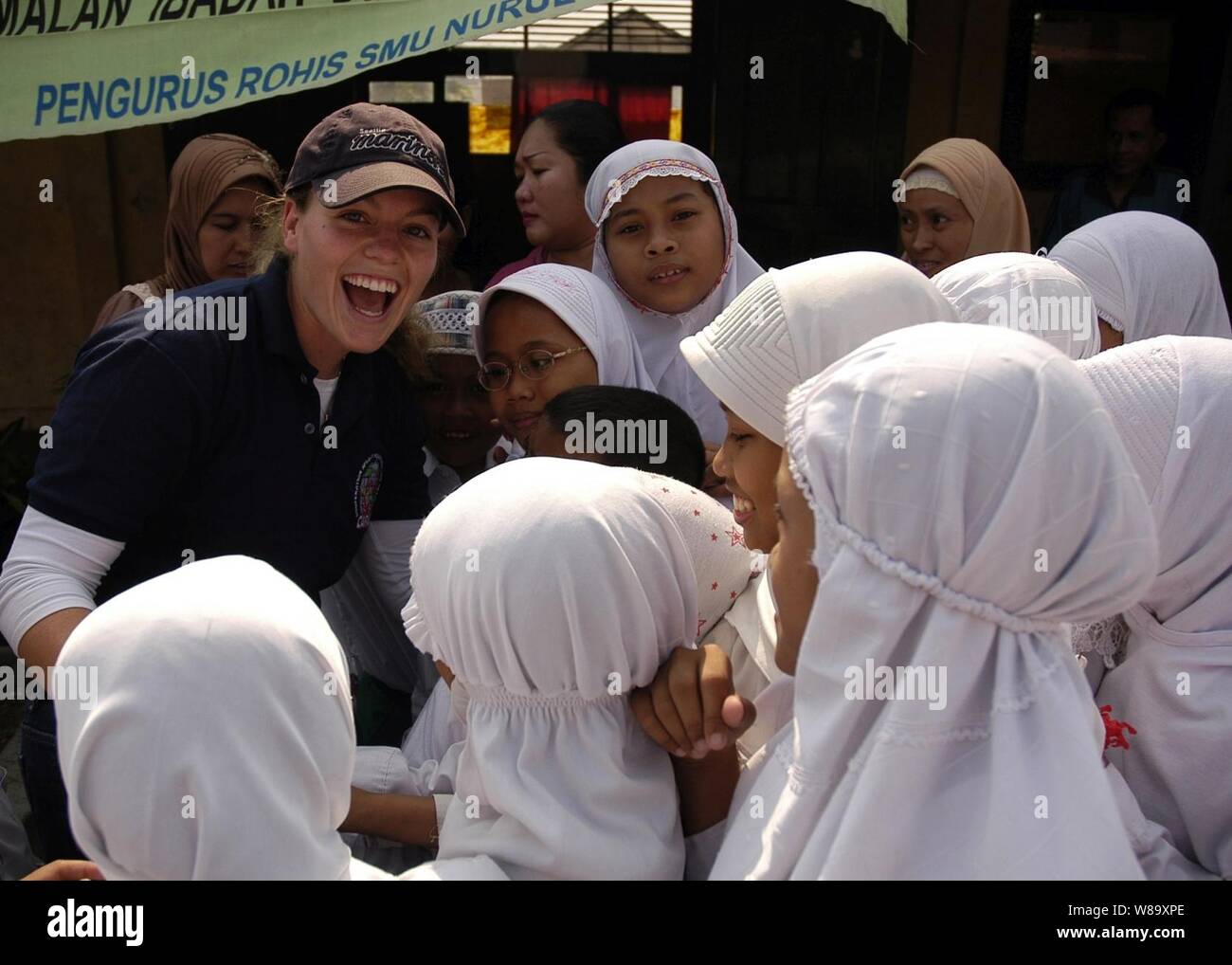 Stati Uniti Navy Ensign Ashley Rushing, assegnato alla USS Russell (DDG 59), accoglie un gruppo di ragazze indonesiane durante un servizio alla comunità il progetto presso Nural Falah scuola elementare, come parte della cooperazione a galla la prontezza e la formazione Indonesia 2009 a Jakarta, Indonesia, su agosto 25, 2009. La cooperazione a galla la prontezza e la formazione è un esercizio annuale condotta tra gli Stati Uniti e sei paesi del Sud-Est asiatico. Foto Stock