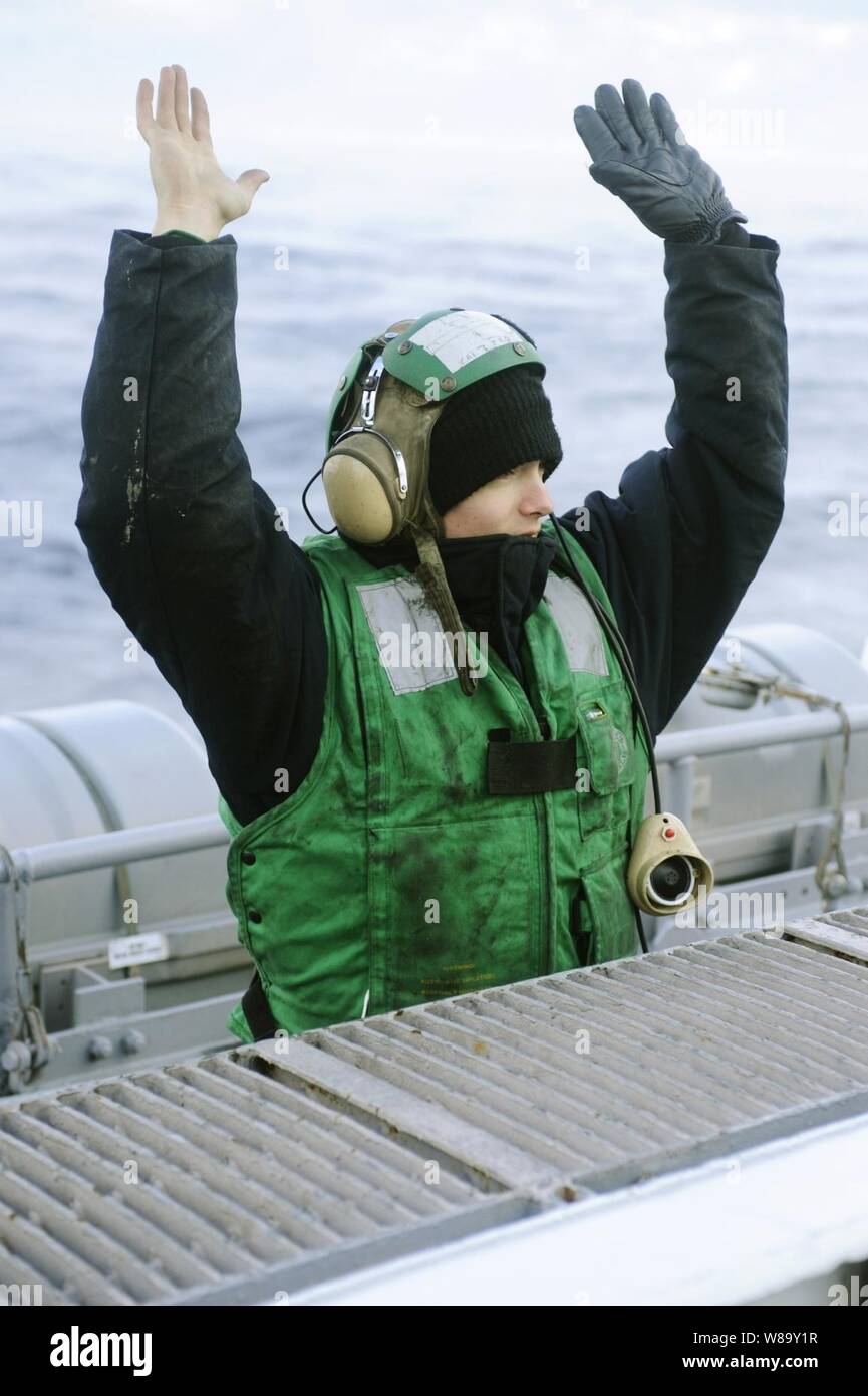 Stati Uniti Navy Petty Officer di 2a classe di Phillip Jukkola segnali 'mani chiaro' durante i preparativi per la sicurezza delle operazioni di volo a bordo della portaerei USS Dwight D. Eisenhower CVN (69) nell'Oceano Atlantico a Gennaio 3, 2010. La Eisenhower è su un periodo di sei mesi la distribuzione come parte del continuo di rotazione avanti-forze dispiegate. Foto Stock
