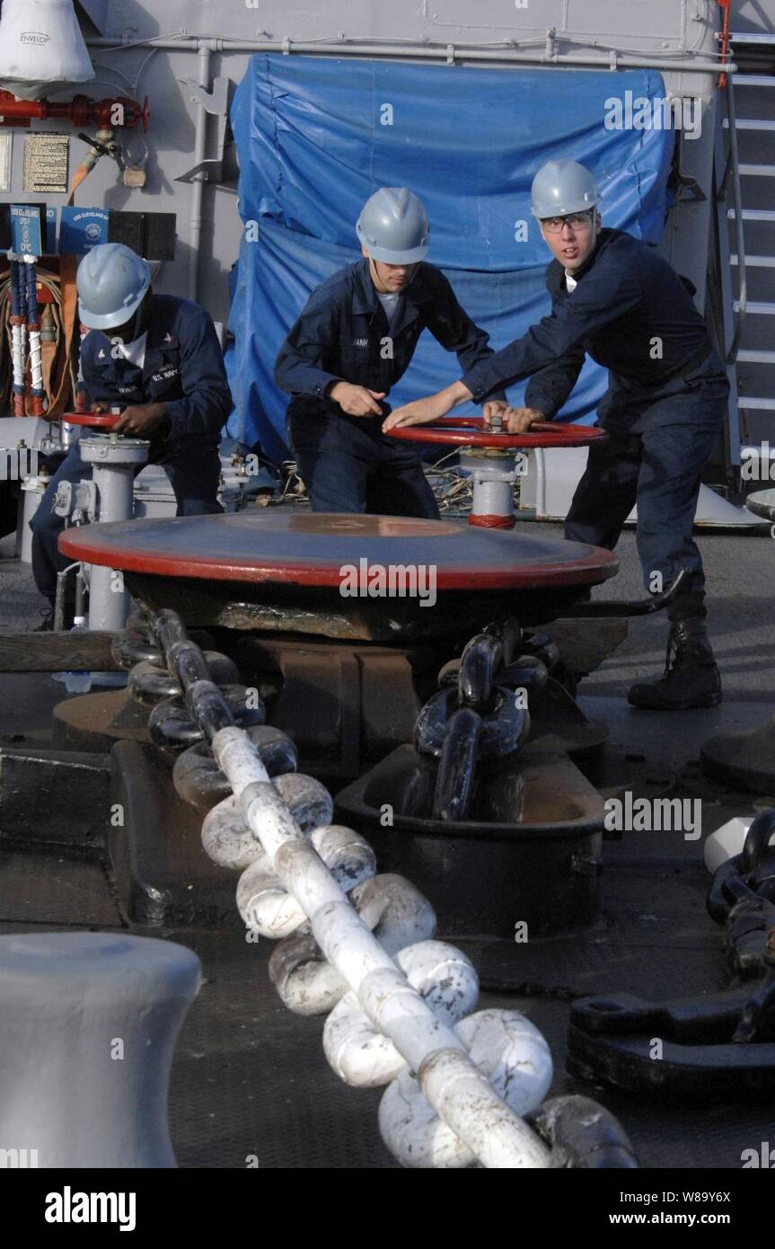 Stati Uniti Navy Petty Officer di terza classe Ryan McLaughlin (sinistra), marinaio Garrett Mann e il Marinaio Michael Campana (a destra) il controllo del verricello salpa ancora mentre cadono ancora a bordo il trasporto anfibio dock nave USS Cleveland (LPD 7) durante l'Orlo del Pacifico, una biennale, multinazionale esercizio inteso a rafforzare i partenariati regionali e migliorare l'interoperabilità multinazionale a Honolulu il 24 giugno 2010. Foto Stock