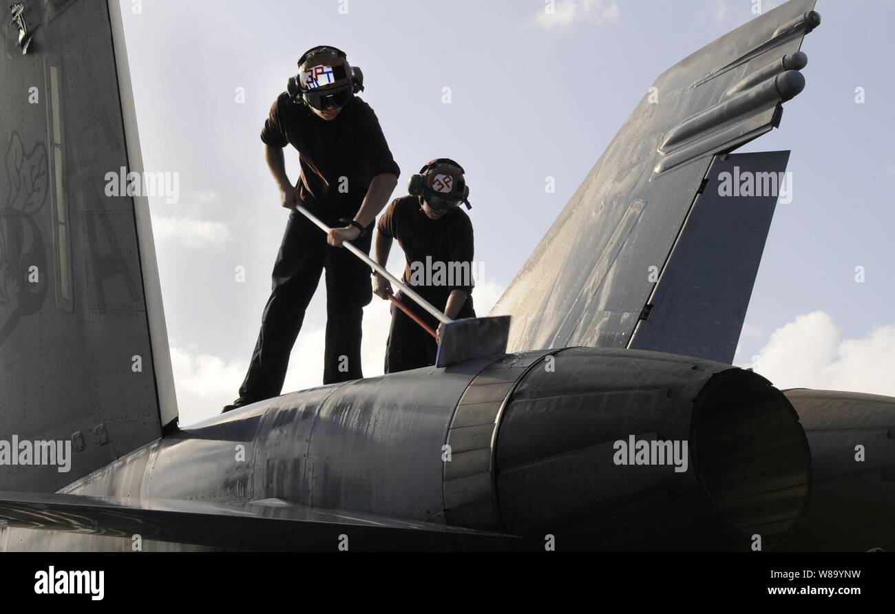 Airman reclutare Teddy Frisby (sinistra) e Airman apprendista Kevin Dwyer, sia assegnato a Strike Fighter Squadron 113, lavare un F/A-18C Hornet sul ponte di volo della portaerei USS Carl Vinson (CVN 70) nel Mar Arabico su 11 Febbraio, 2011. La Carl Vinson Carrier Strike gruppo è implementato il supporto le operazioni di sicurezza marittima e di teatro la cooperazione in materia di sicurezza gli sforzi negli Stati Uniti Quinta Flotta area di responsabilità. Foto Stock