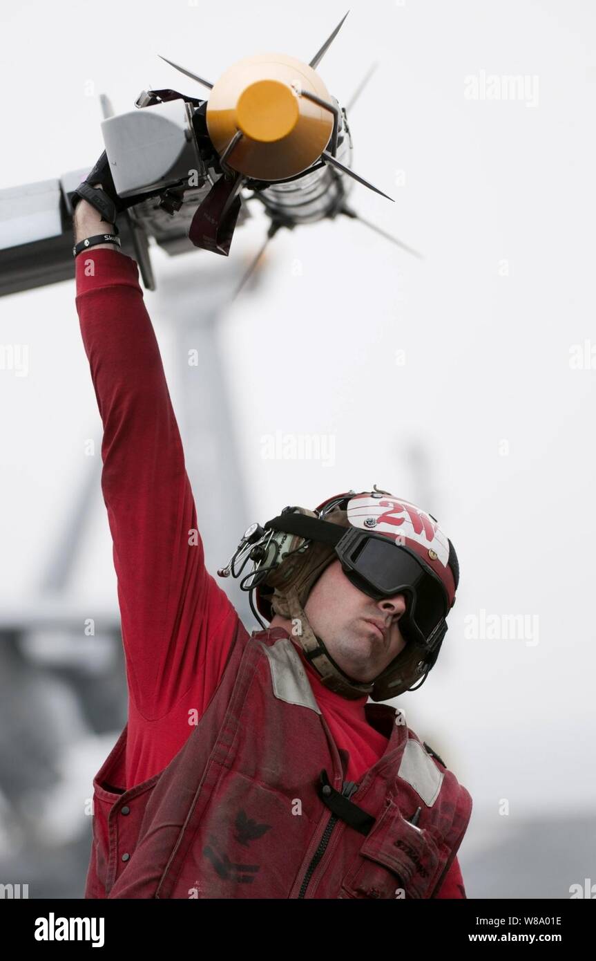 Petty Officer di 2a classe di Jason Cooley, assegnato a Strike Fighter Squadron 81, abbassa la punta delle ali di un F/A-18E Super Hornet di aerei di offload di munizioni a bordo della portaerei USS Carl Vinson (CVN 70) in corso nel Golfo Arabico il 5 aprile 2011. La Carl Vinson e Carrier aria Wing 17 stanno conducendo le operazioni di sicurezza marittima e di vicino-air le missioni di sostegno negli Stati Uniti Quinta Flotta area di responsabilità. Foto Stock