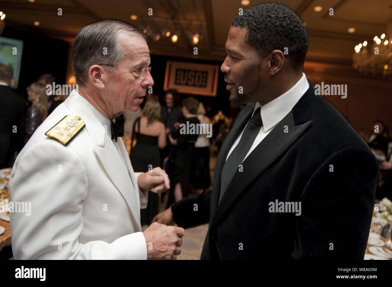 Presidente del Comune di capi di Stato Maggiore Adm. Mike Mullen, U.S. Navy, parla con New York Giant difensivo fine Michael Strahan al 2011 OSU Metro premi la cena al Ritz Carlton Hotel in Pentagon City, Virginia, il 12 aprile 2011. Foto Stock