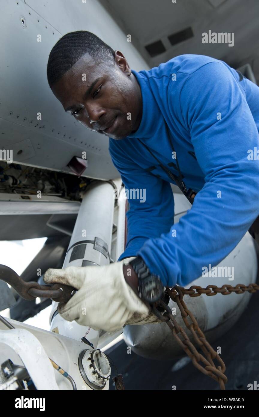 Airman Cameron Brown attribuisce una catena ad un F/A-18F Super Hornet assegnati a Strike Fighter Squadron 41 a bordo della portaerei USS John C. Stennis CVN (74) in corso nell'Oceano Pacifico su agosto 16, 2011. John C. Stennis Carrier Strike gruppo è su una distribuzione programmata all'Oceano Pacifico occidentale e del Golfo Arabico. Foto Stock