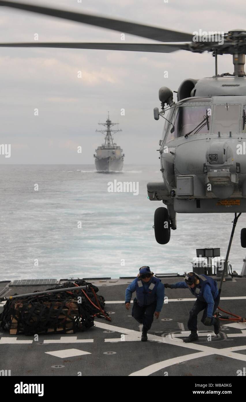 Marinaio Lucio Robles (sinistra) e il Marinaio Daniel Nogal cancella il ponte di volo delle visite-missile destroyer USS Mitscher (DDG 57) dopo il fissaggio di una rete da carico per un MH-60R Sea Hawk elicottero elicottero sciopero marittimo Squadron 70 durante un rifornimento verticale in mare nell'Oceano Atlantico su nov. 29, 2011. In fondo è la visita-missile destroyer USS Truxtun (DDG 103). La Mitscher e il Truxtun sono distribuiti negli Stati Uniti Sesta flotta area di responsabilità condurre le operazioni di sicurezza marittima e di protezione del teatro gli sforzi di cooperazione. Foto Stock