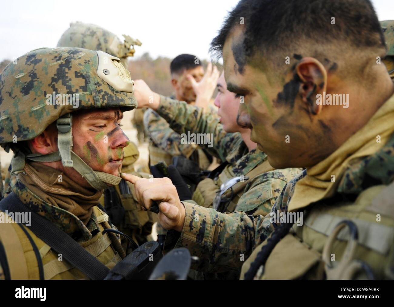 Cpl. Mario Melendez (a destra), assegnato a seconda del plotone, società Pacific, flotta antiterrorismo del team di protezione si applica vernice camouflage per Lance Cpl. Tyler Courtney prima un movimento tattico di esercizio a Camp Rodriguez, Repubblica di Corea, il 3 marzo 2012. Circa 50 Marines svolto attività di formazione presso il Camp Rodriguez Live Fire complesso. Foto Stock
