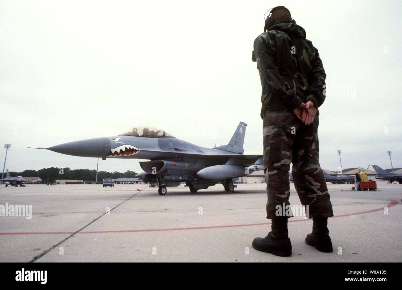 Stati Uniti Air Force Senior Airman Jon Basar attende per dare il segnale di Capt. Brett McCann per lanciare il suo F-16 Fighting Falcon da Papa Air Force Base, N.C., in data 7 maggio 1996, per la simulazione di una missione di combattimento durante la Combined Joint Task Force esercizio Ф96. Più di 53.000 servizio militare membri provenienti da Stati Uniti e Regno Unito stanno partecipando in Combined Joint Task Force esercizio Ф96 su installazioni militari nel sud-est degli Stati Uniti e nelle acque lungo la costa orientale. Basar e McCann sono attaccati alla 74Fighter Squadron al Papa. Foto Stock