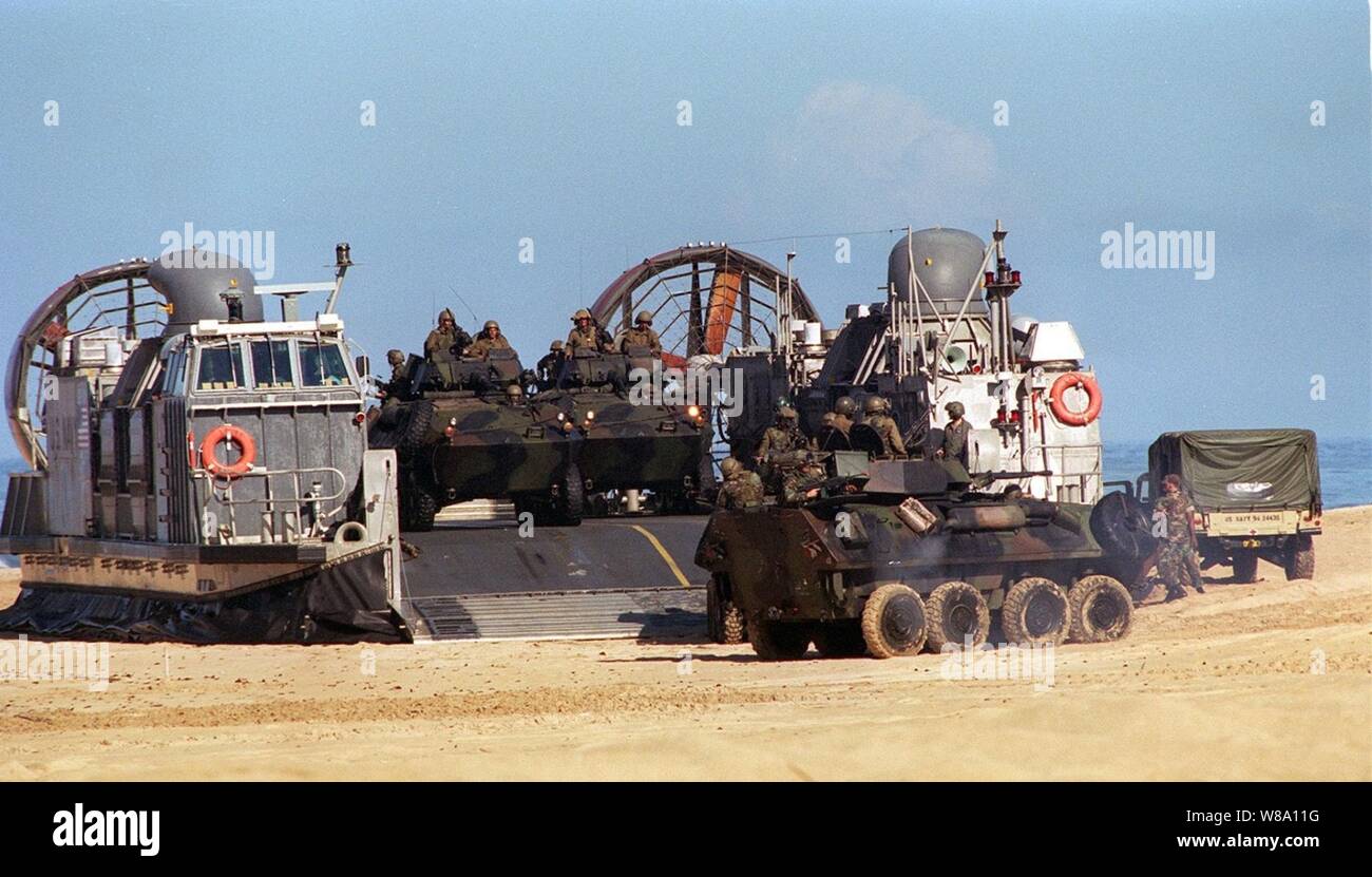 Stati Uniti Marine Corps Humvees e luce Veicoli blindati di roll off ponte di una U.S. Navy Landing Craft Air Cushion durante un atterraggio anfibio a giugno 15, 1996, come parte del RIMPAC Ф96. L'assalto anfibio al Pacific Missile Range Facility, Barking Sands, Hawaii, è condotto da undicesimo Marine Expeditionary Unit, Camp Pendleton, California, e coinvolge la marina e di aria per applicazioni marine, massa e forze di mare per la formazione come una combinazione di assalto anfibio vigore. Più di 44 navi, 200 aerei e 30.000 soldati, marinai, Marines, avieri e sulla costa guardie sono coinvolti nell'esercizio. Lo scopo di RIM Foto Stock
