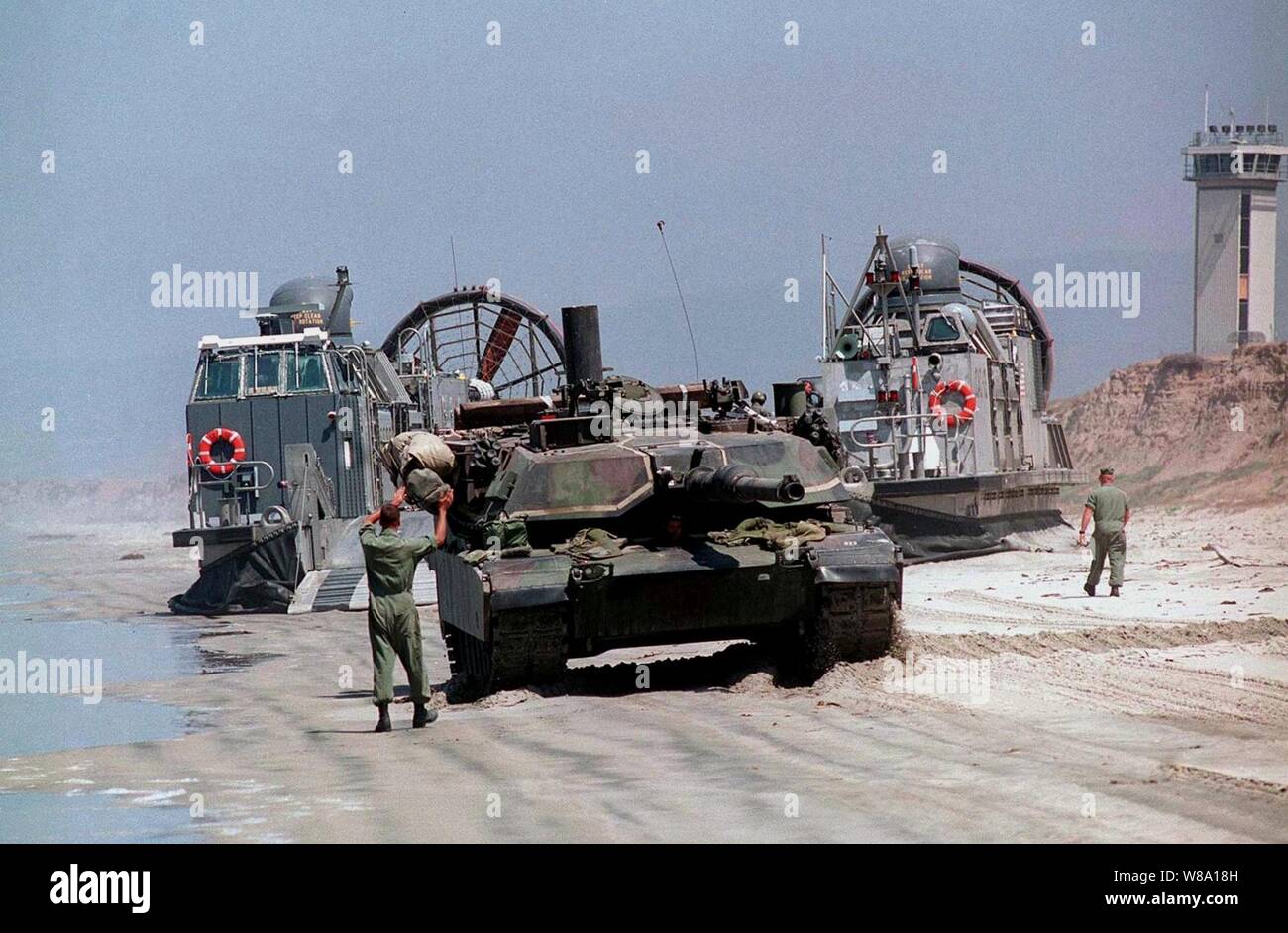 Il conducente di un U.S. Marine Corps M-1A1 serbatoio di Abrams è la massa guidata come egli sostiene su un U.S. Navy Landing Craft Air Cushion o LCAC, in quanto si trova sulla spiaggia bianca, Camp Pendleton, California, il 20 giugno 1997, durante l'esercizio Kernel Blitz 97. Kernel Blitz 97 è un importante esercizio di anfibio che avvengono nella California del Sud e acque offshore. Più di 12.000 velisti, Marines, soldati, guardie e gli avieri sono coinvolti nell'esercizio che è progettata per testare il Navy-Marine Corps teamХs capacità di progetto la potenza di combattimento a terra. Il LCAC, dall assalto unità artigianali 5, si cala il serbatoio, cargo e Foto Stock