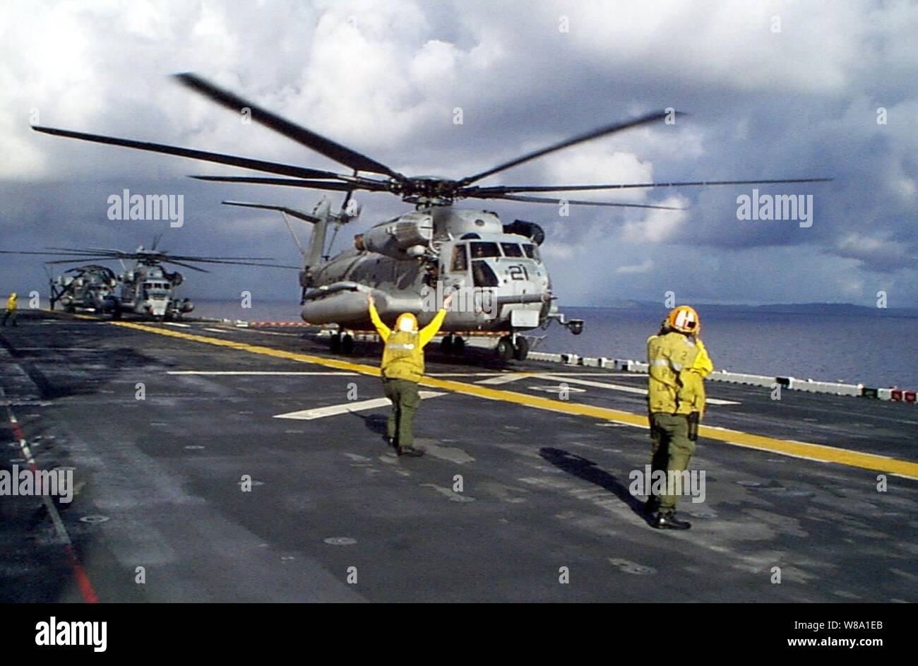 Una Marina lo sbarco del segnale segnali arruolato un U.S. Marine Corps CH-53 Super Stallion elicottero per sollevare dall'assalto anfibio nave USS Wasp (LHD 1) a Gennaio 17, 1998, durante la Joint Task Force esercizio 98-1. Più di 30.000 personale militare degli Stati Uniti partecipano all'esercizio che è il testing forze congiunte sulla loro capacità di distribuire rapidamente e condurre operazioni congiunte durante una crisi. Tutti i rami delle forze armate sono la formazione di lato-da-lato utilizzando le più recenti innovazioni nella tecnologia in una simulazione di alta minaccia ambiente che coinvolge aria, navale e le operazioni a terra. Foto Stock