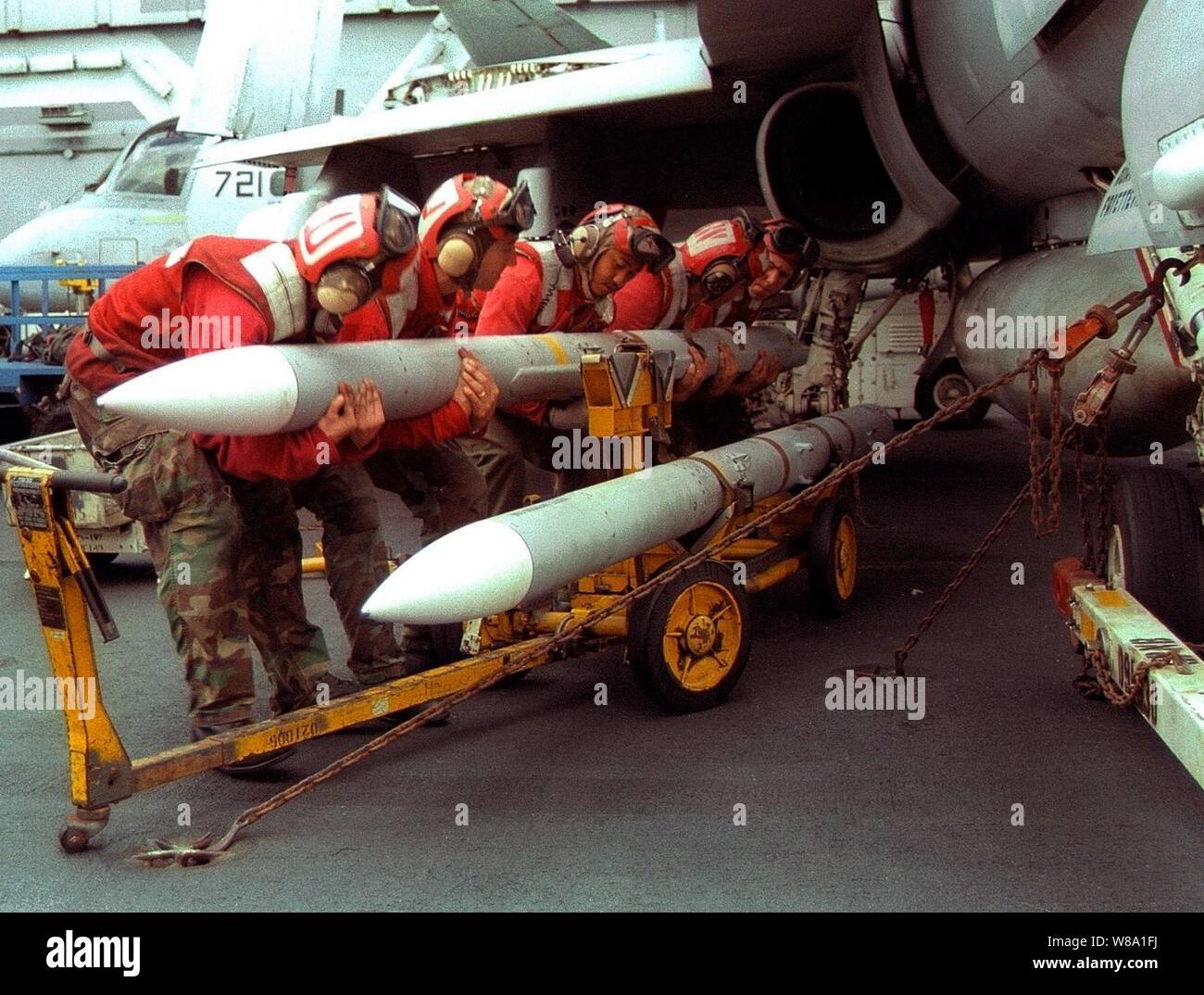 Un team di aviazione ordnancemen culla un obiettivo-7 Sparrow a medio raggio air-air missile come essi carico su una F/A-18 Hornet sul ponte di volo della USS Indipendenza (CV 62) mentre la nave opera nel Golfo Persico nel Febbraio 7, 1998. Indipendenza e la sua avviato Carrier aria Wing 5 sono in stazione nel Golfo Persico a sostegno del funzionamento orologio meridionale che sono gli Stati Uniti e le forze della coalizione esecuzione della no-fly zone su Iraq meridionale. Foto Stock