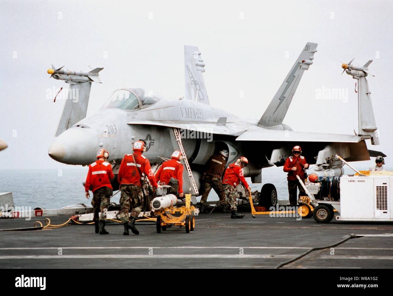 Aviation ordnancemen da Marine attacco Fighter Squadron 251 missili di carico su una F/A-18C Hornet sul ponte di volo della portaerei USS George Washington (CVN 73) come la nave cuoce a vapore nel Golfo Persico a gennaio 29, 1998. La Washington battle group è operativo nel Golfo Persico a sostegno del funzionamento orologio meridionale che sono gli Stati Uniti e le forze della coalizione esecuzione della no-fly zone su Iraq meridionale. Foto Stock