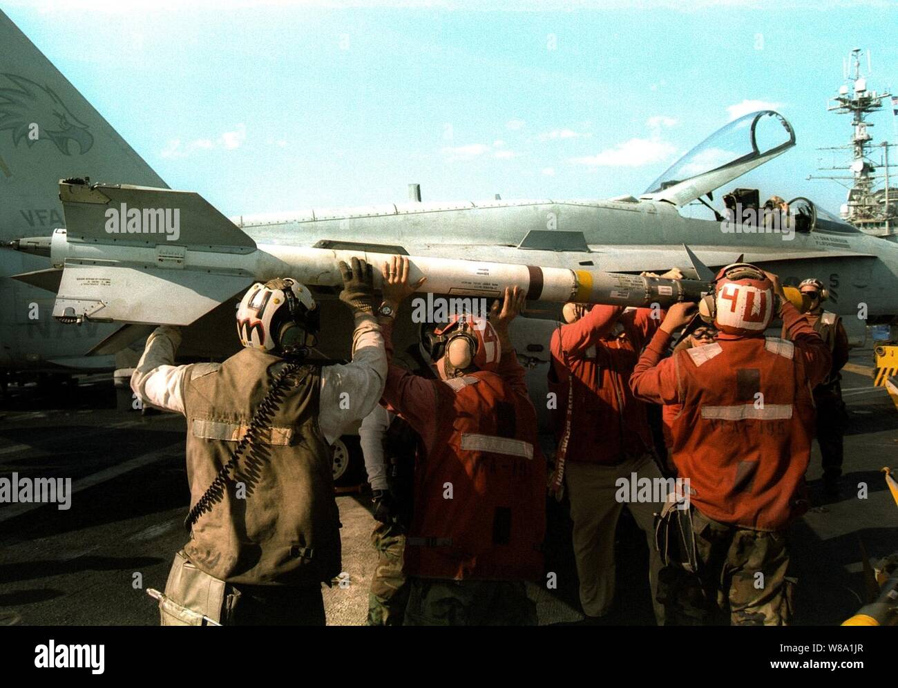 Aviation ordnancemen caricare un AIM Sidewinder short range missile su una F/A-18 Hornet sul ponte di volo della USS Indipendenza (CV 62) mentre la nave opera nel Golfo Persico nel febbraio 10, 1998. Indipendenza e la sua avviato Carrier aria Wing 5 sono in stazione nel Golfo Persico a sostegno del funzionamento orologio meridionale che sono gli Stati Uniti e le forze della coalizione esecuzione della no-fly zone su Iraq meridionale. Foto Stock