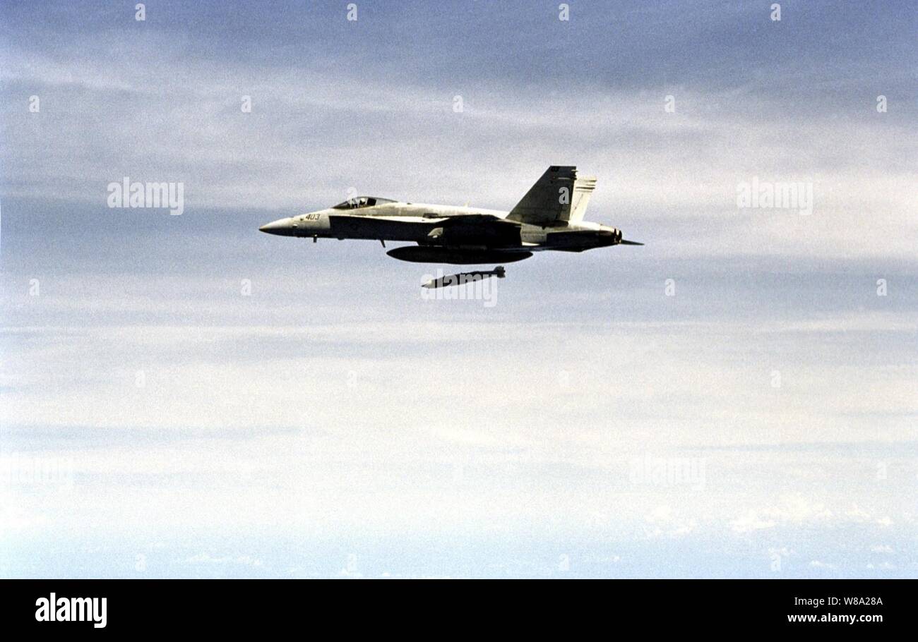 Un U.S. Navy F/A-18C Hornet rilascia un giunto di attacco diretto alle munizioni (JDAM) nel primo squadrone della flotta caduta della nuova arma sviluppata durante il corso di formazione a Okinawa, Giappone Area dell'intervallo su agosto 22, 1999. JDAM utilizza un sistema di posizionamento globale aided sistema di navigazione inerziale per guidare i suoi 2.000 o 1.000 pound warhead al bersaglio con un elevato grado di precisione. Il Hornet, attaccato a Strike Fighter Squadron 195 della stazione navale di Yokosuka, Giappone, è operativo dal ponte di volo della portaerei USS Kitty Hawk (CV 63). Foto Stock