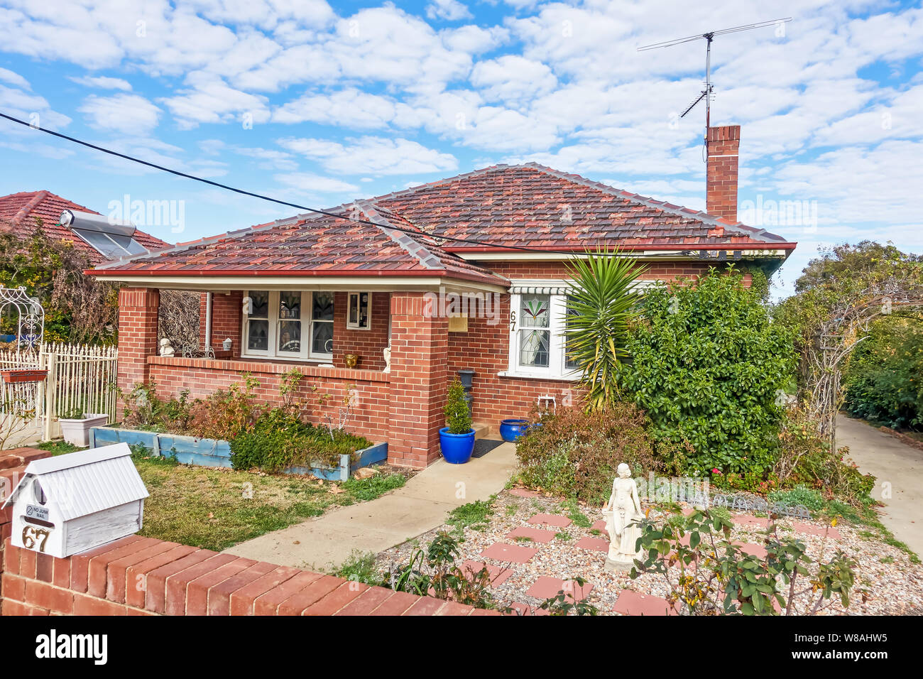 1920s bungalow in muratura con piastrelle di terracotta con tetto e pareti in mattoni delimitatore anteriore. Tamworth Australia. Foto Stock