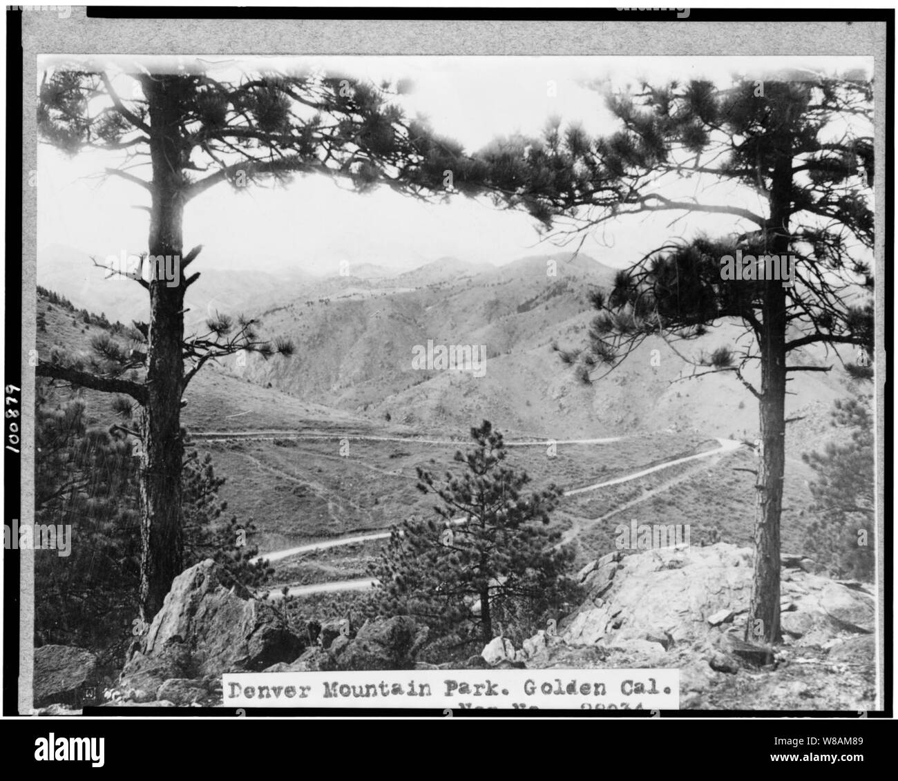 Denver Mountain Park, Golden, Colorado. Vista attraverso gli alberi che si affaccia su strada e montagne Foto Stock