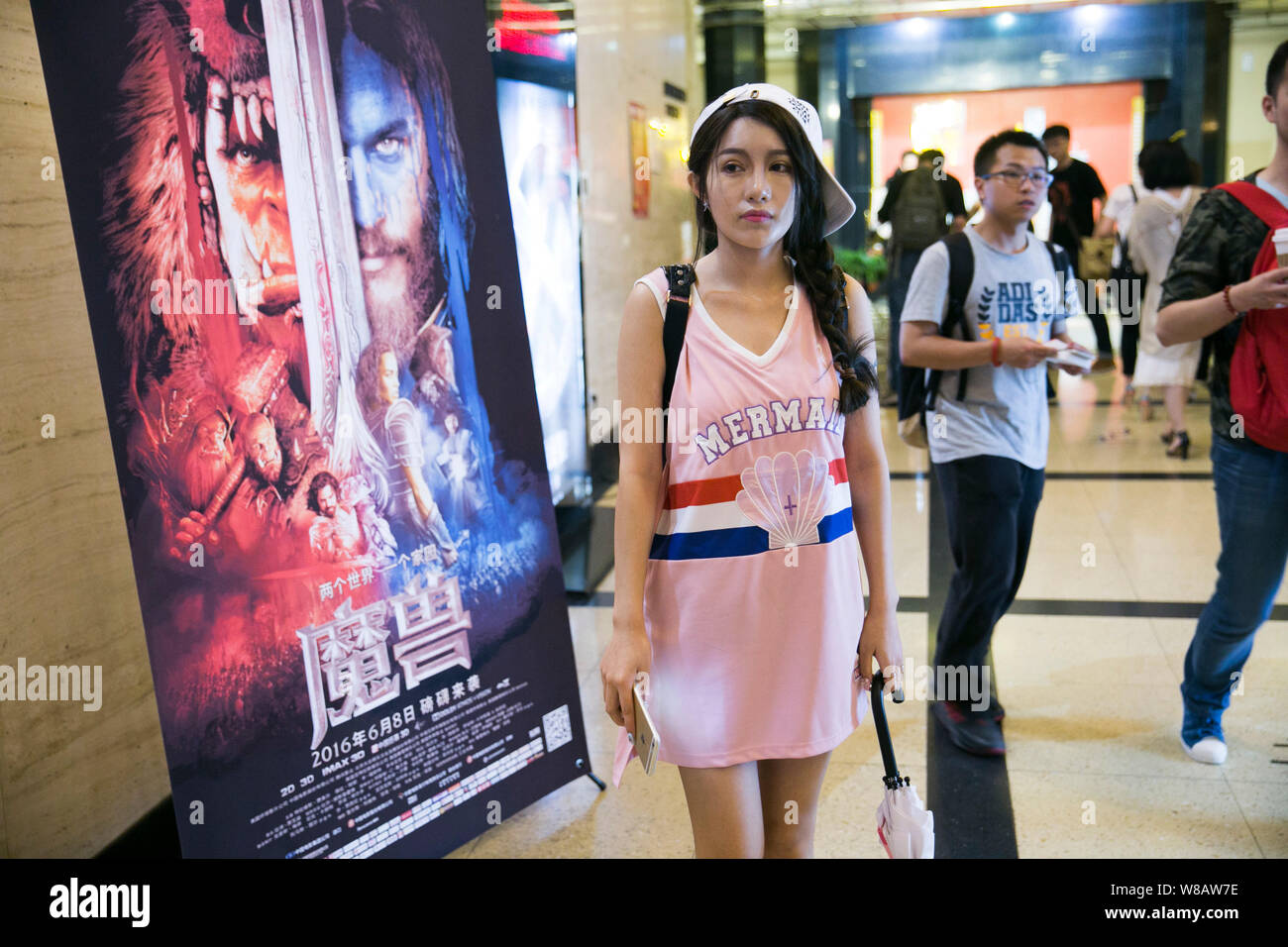 Filmgoers cinese a piedi passato un poster del film 'Warcraft' durante una premiere a un cinema in Cina a Shanghai, 7 giugno 2016. "Warcraft,' la Cinese-bac Foto Stock